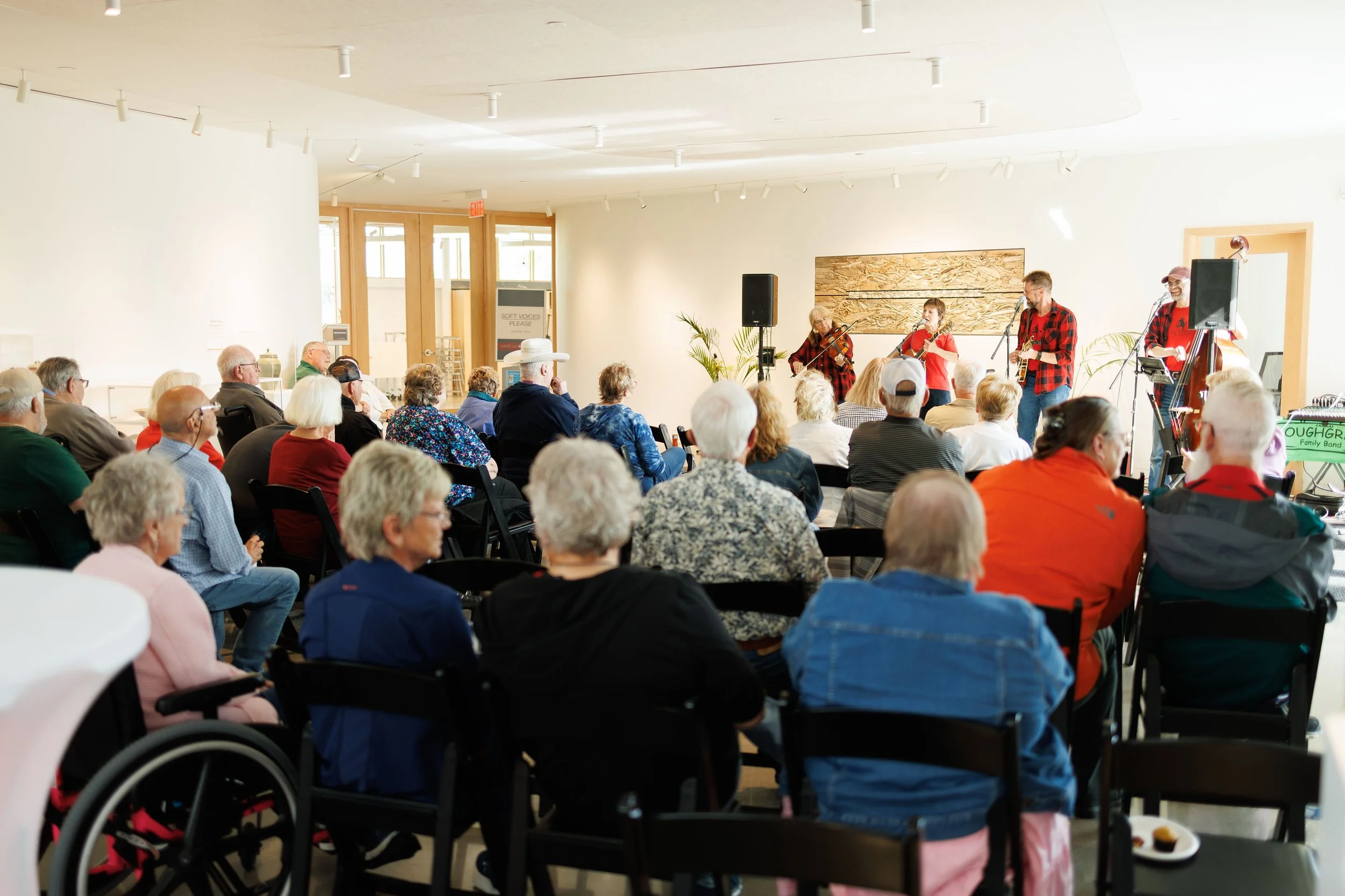 a crowd listening to a performance in the RiverPlace gallery