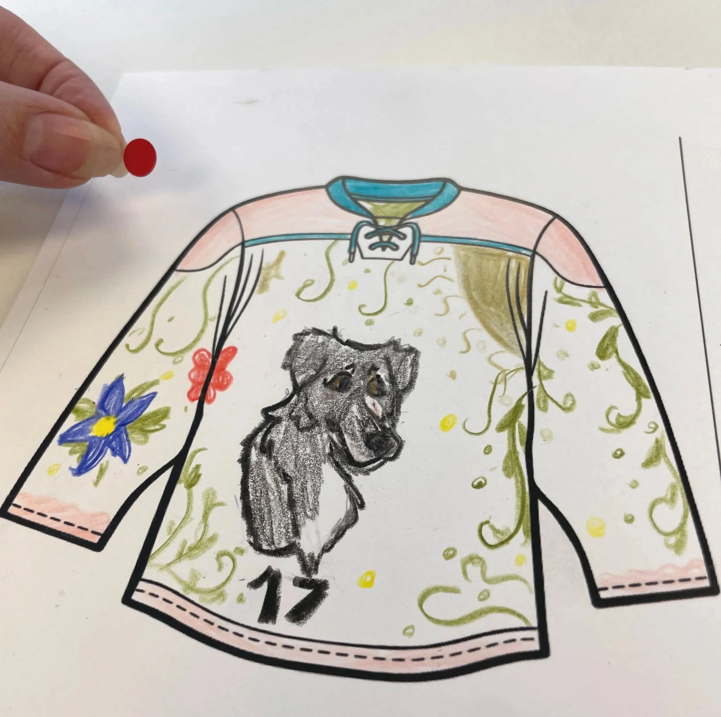 a decorated jersey with a dog and flowers with a hand holding a red dot for voting