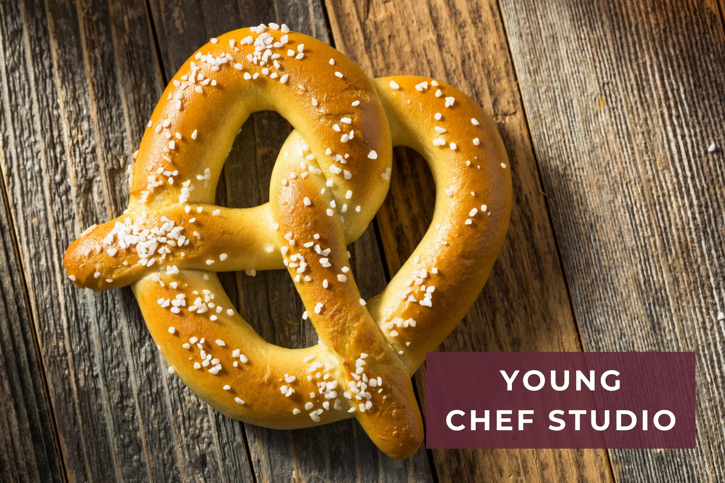 a soft pretzel with salt on a wood table