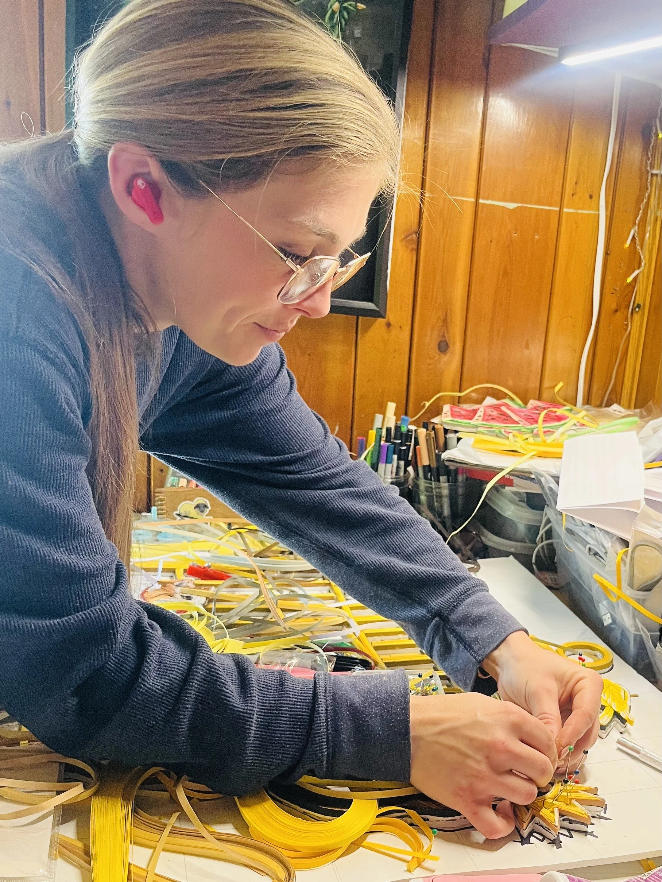 an image of the artist Nikki Besser at work on a paper quilling project in her studio