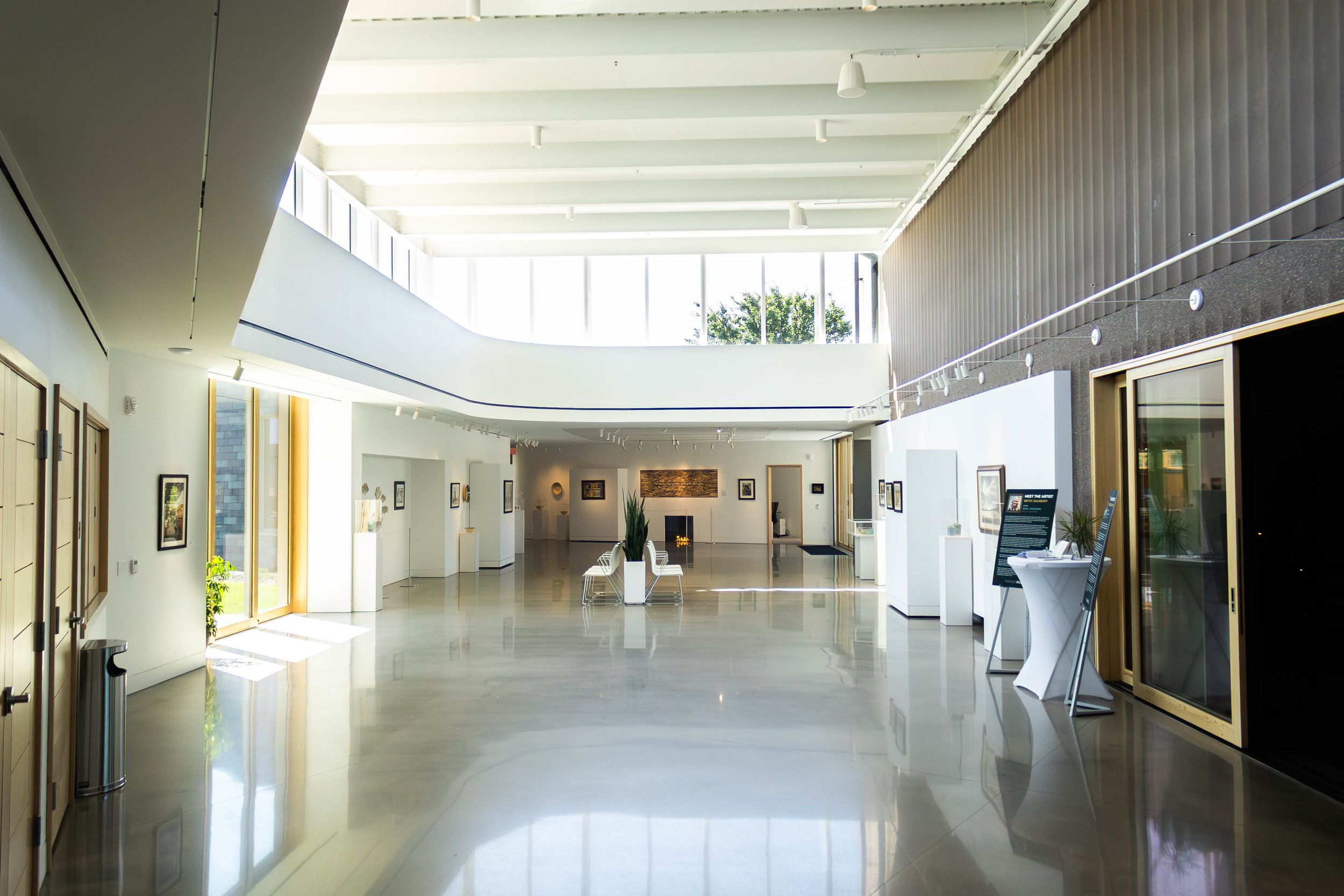 a view of the light-filled RiverPlace gallery from the entrance of the building