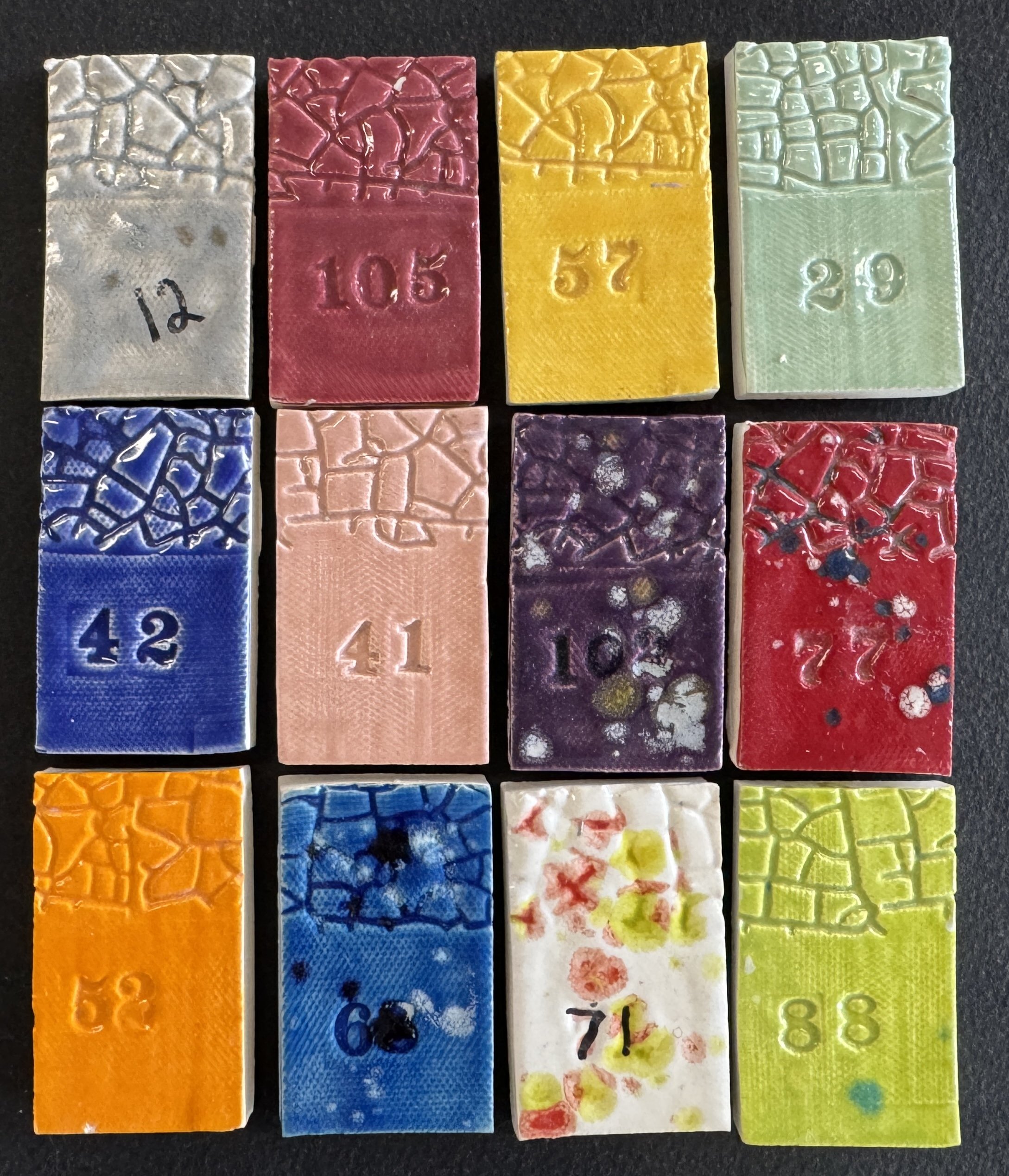 a swatch of 12 different colors of pottery glazing