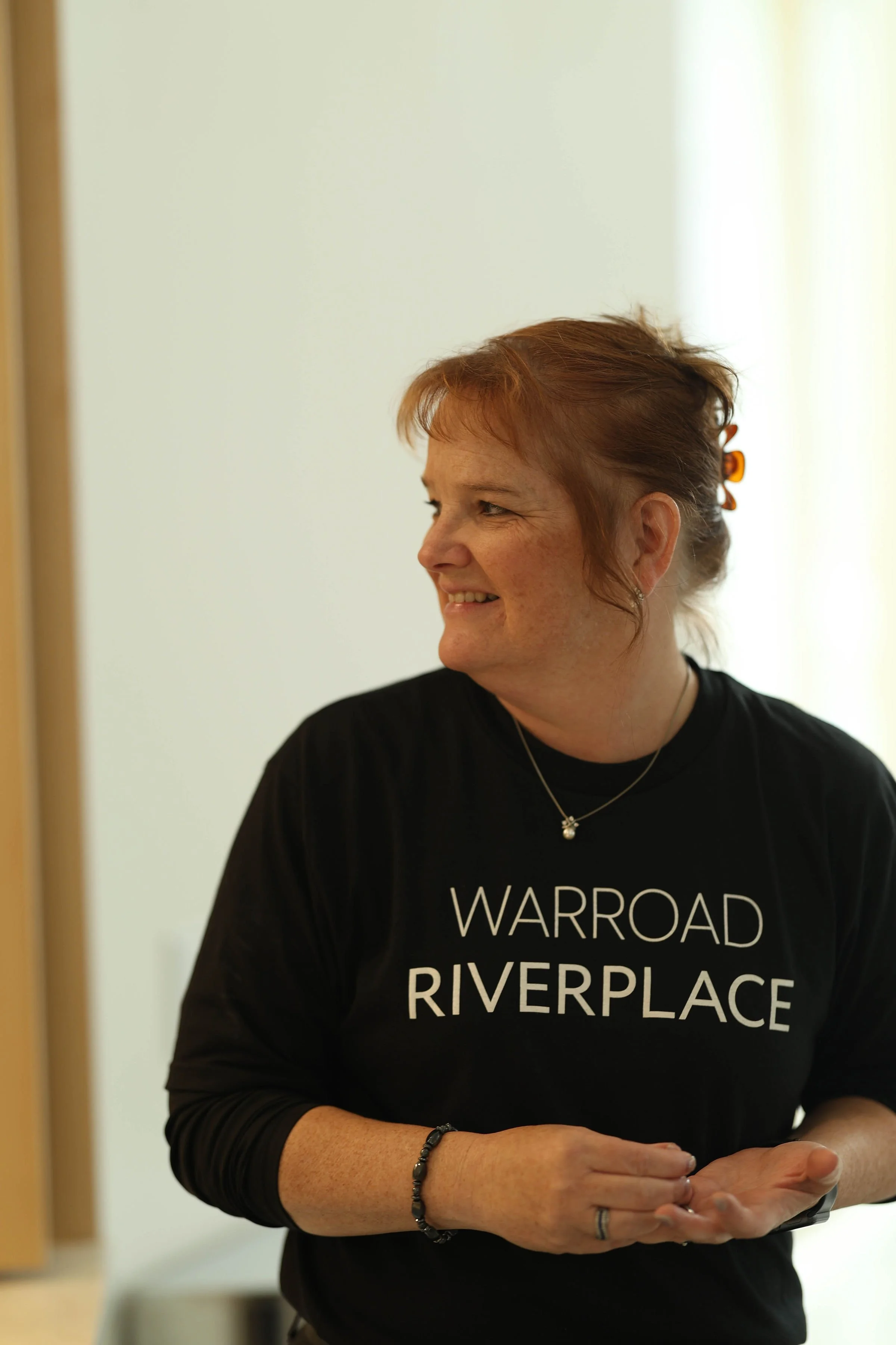 a photo of a woman smiling wearing a Riverplace shirt