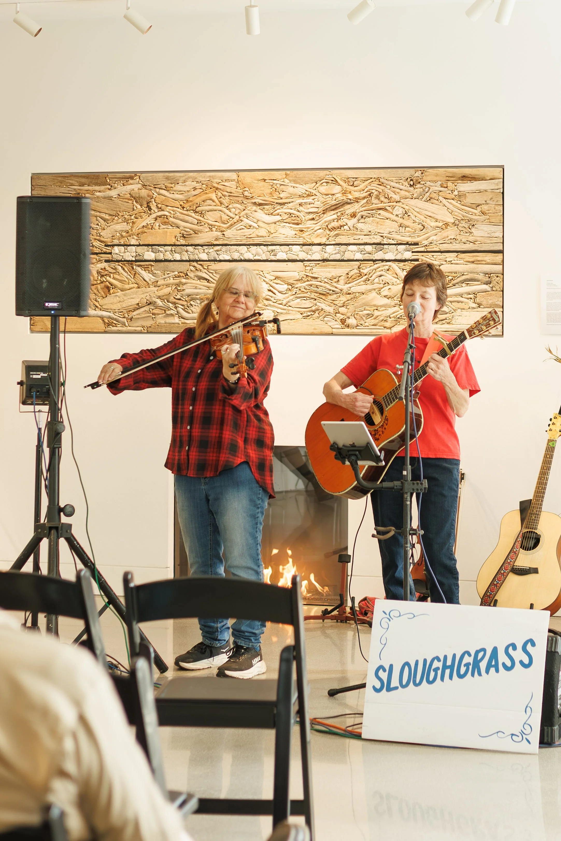 a violinist and a guitarist performing in the RiverPlace gallery