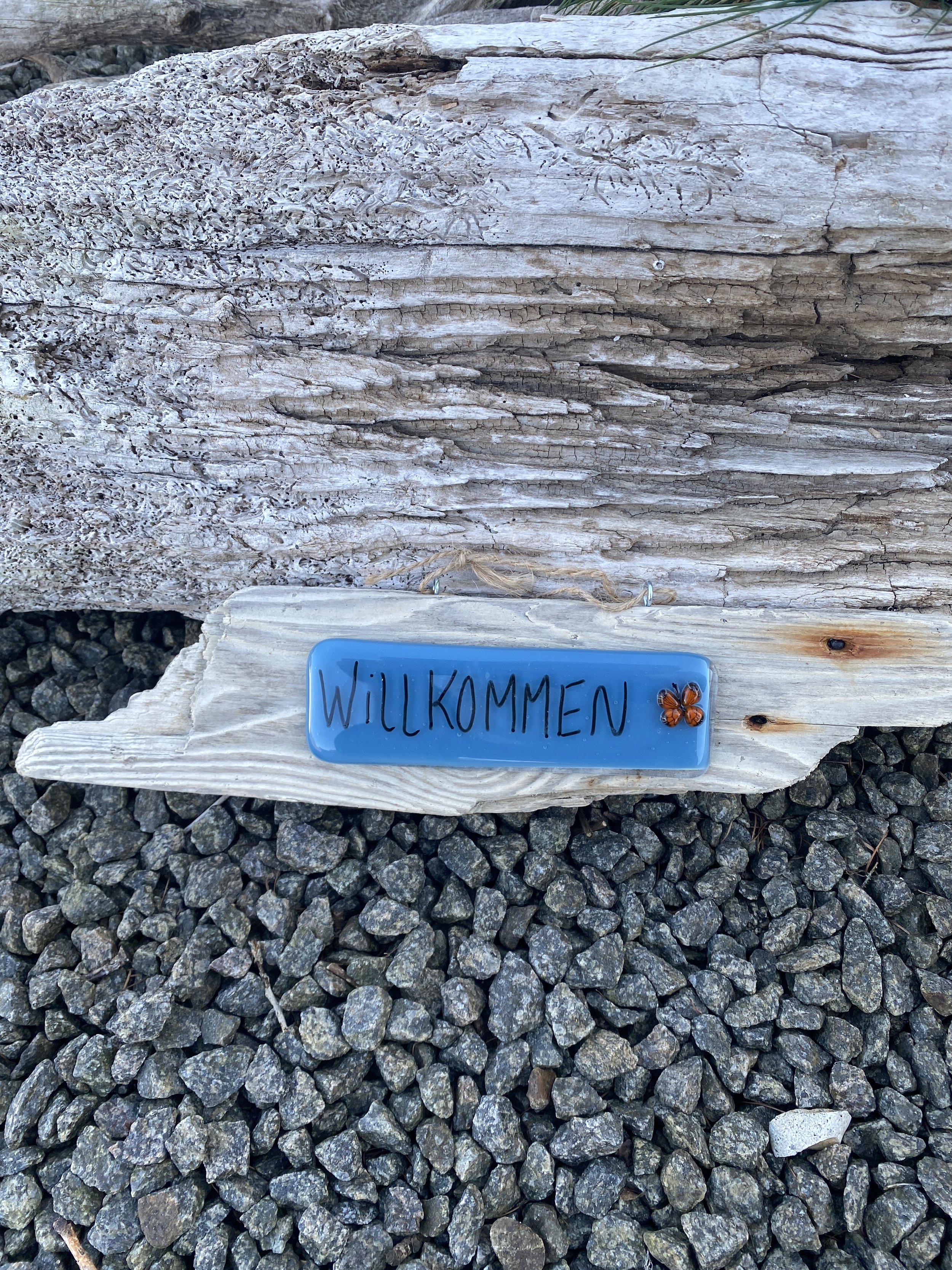 “Willkommen” schild auf treibholz