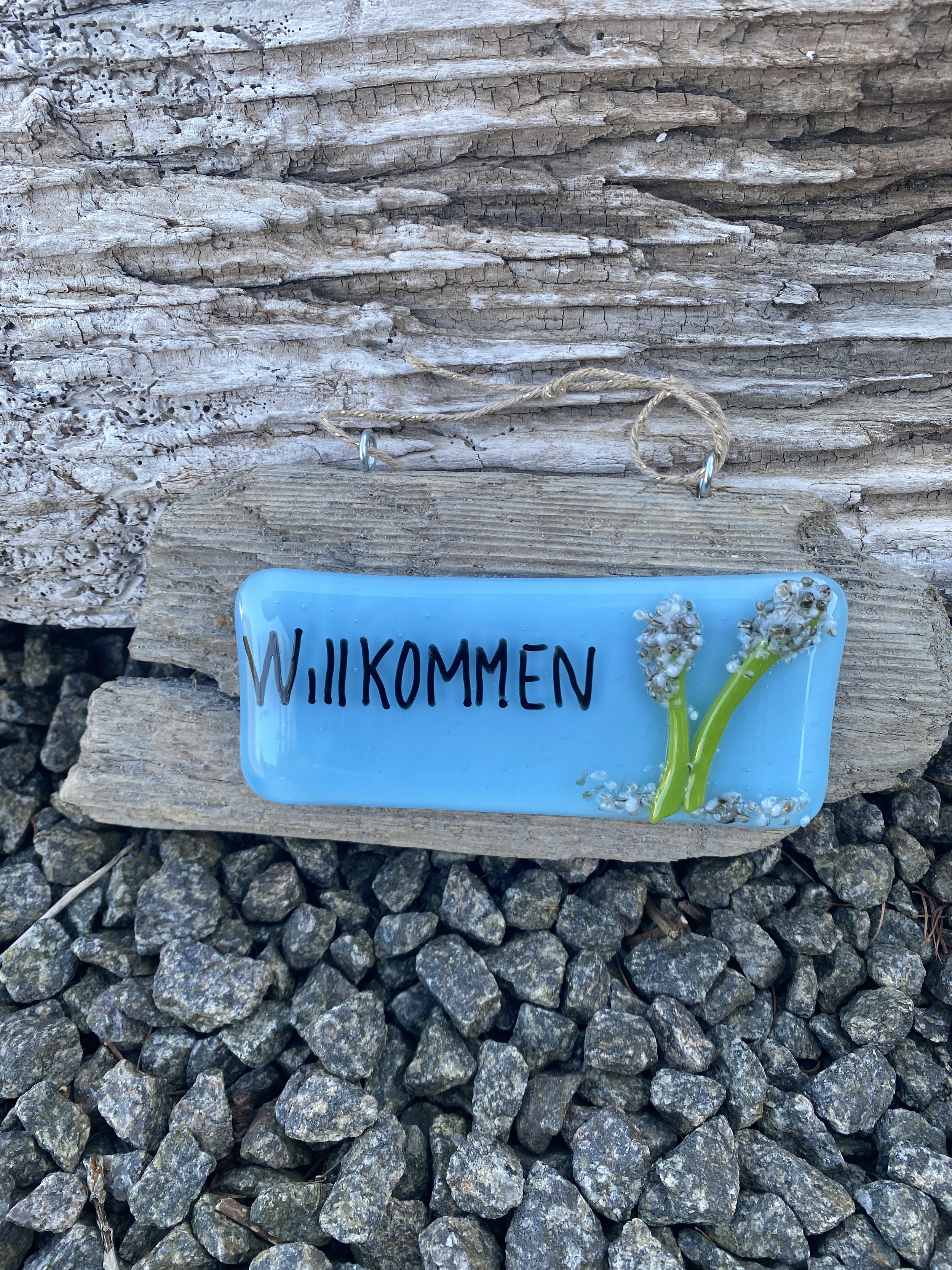 “Willkommen “ schild auf treibholz
