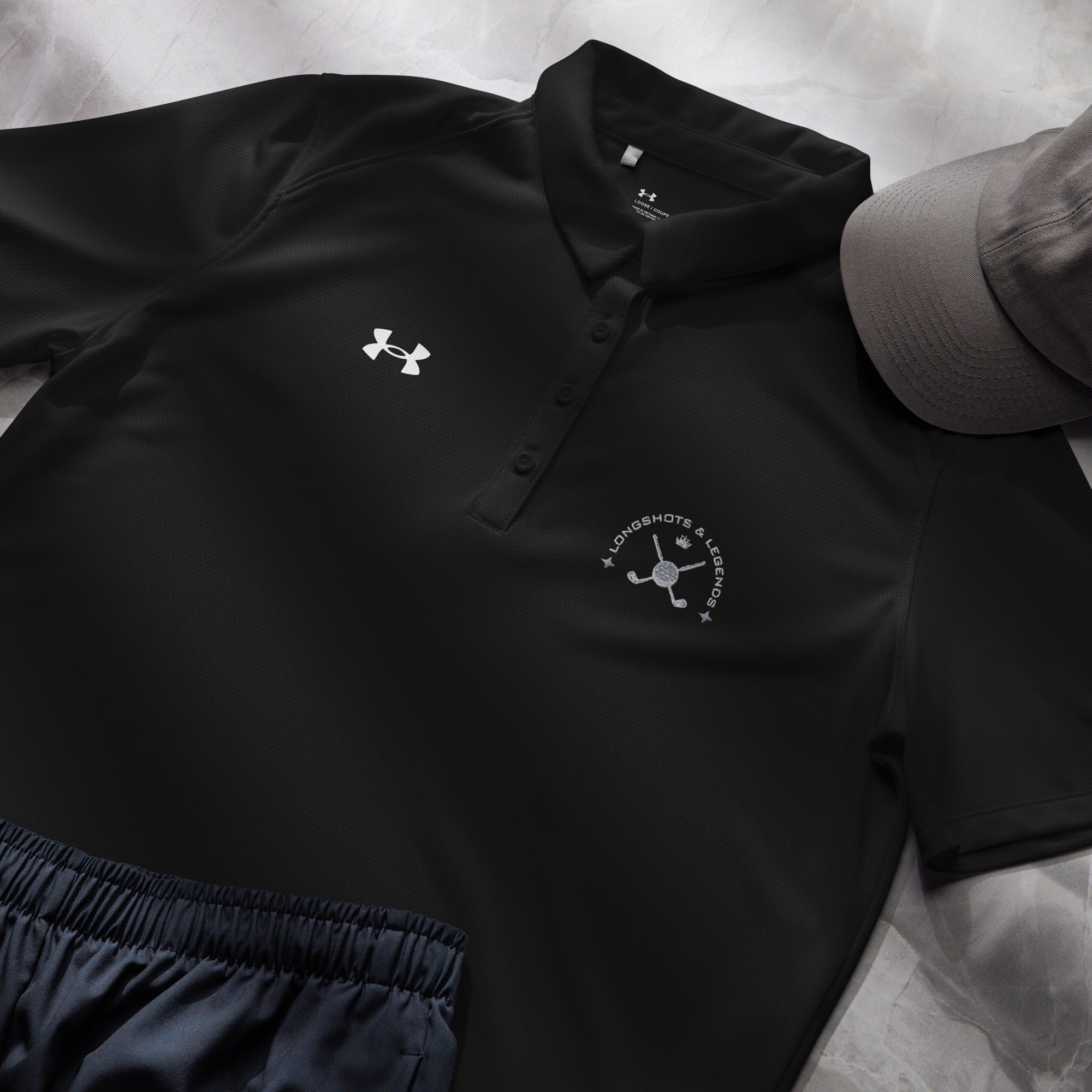 Custom embroidered women’s Under Armour® collared polo shirt with golf logo in black. Celebrate with the Longshots and Legends collection of athletic wear.