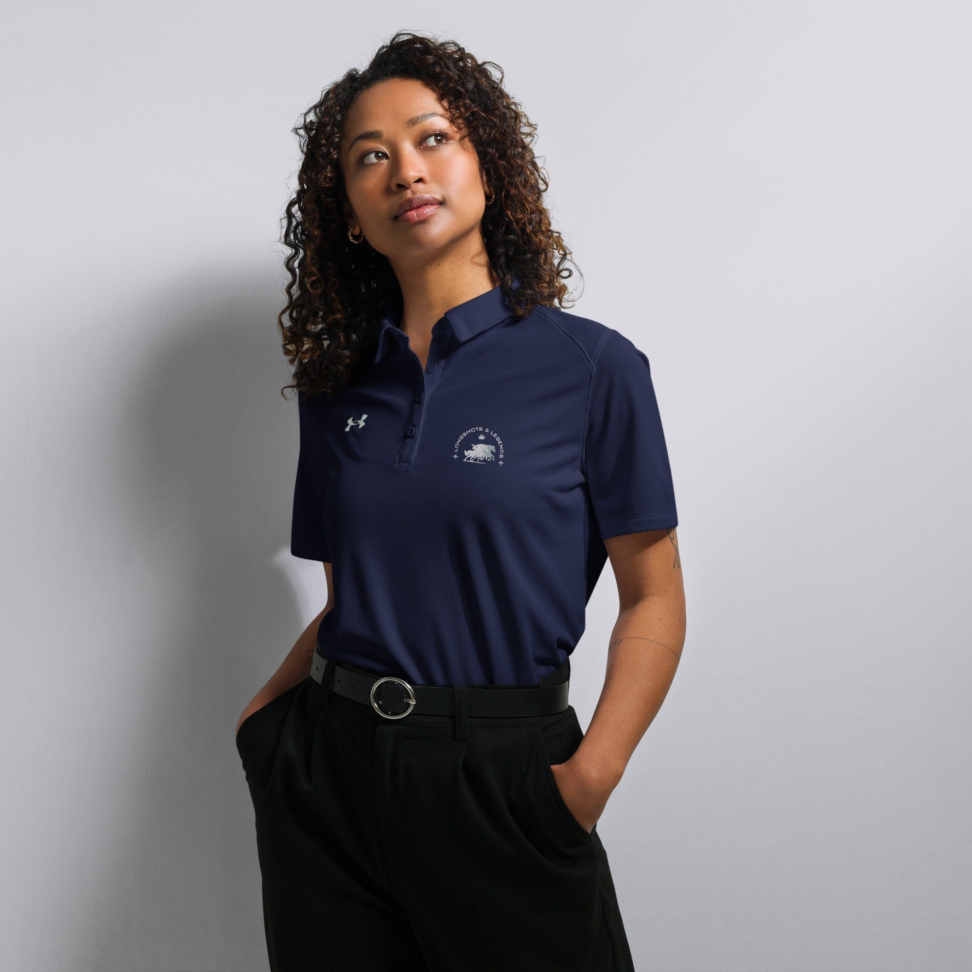 Custom embroidered women’s Under Armour® collared polo shirt with horse logo in navy blue. Celebrate with the Longshots and Legends collection of athletic wear.