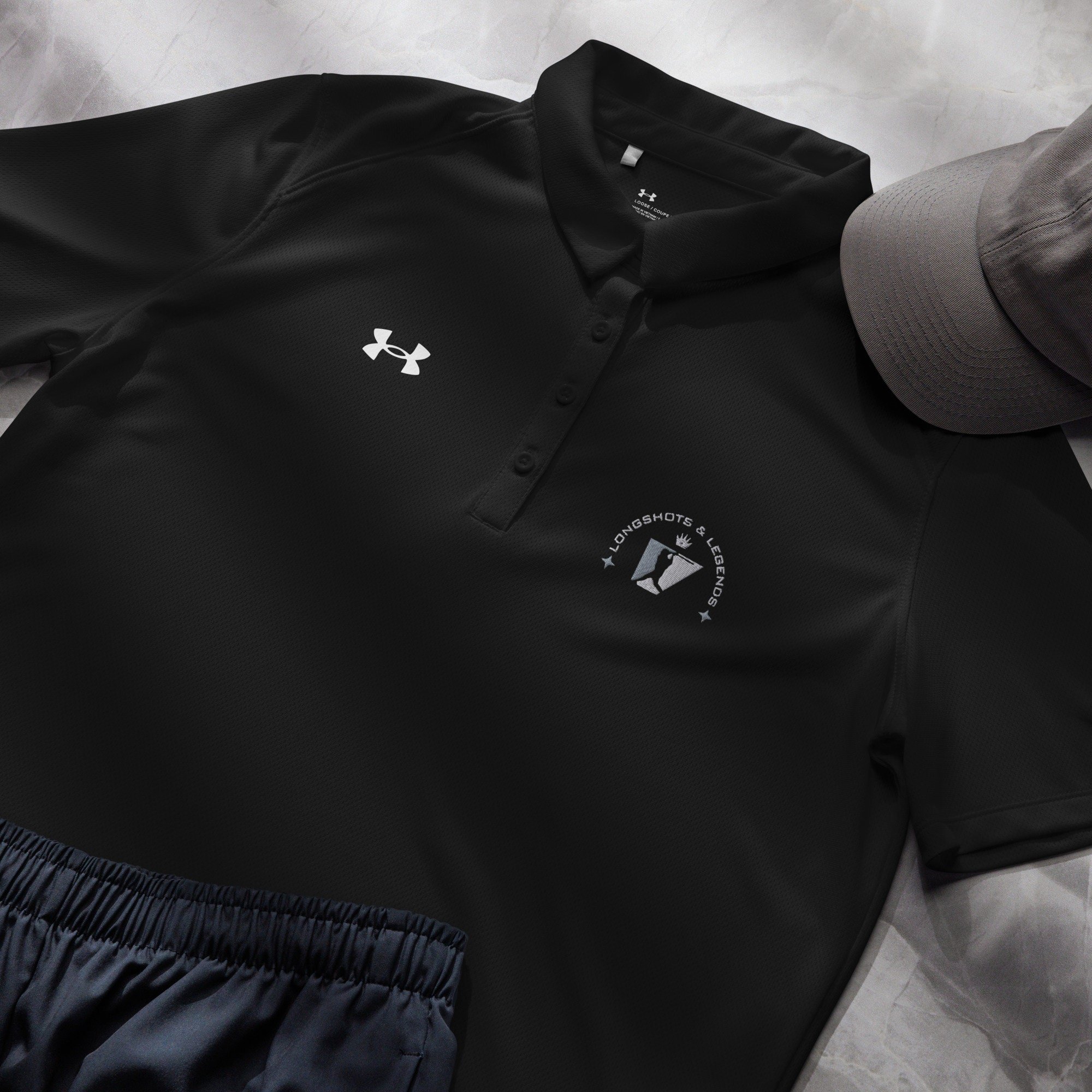 Custom embroidered women’s Under Armour® collared polo shirt with baseball logo in black. Celebrate with the Longshots and Legends collection of athletic wear.