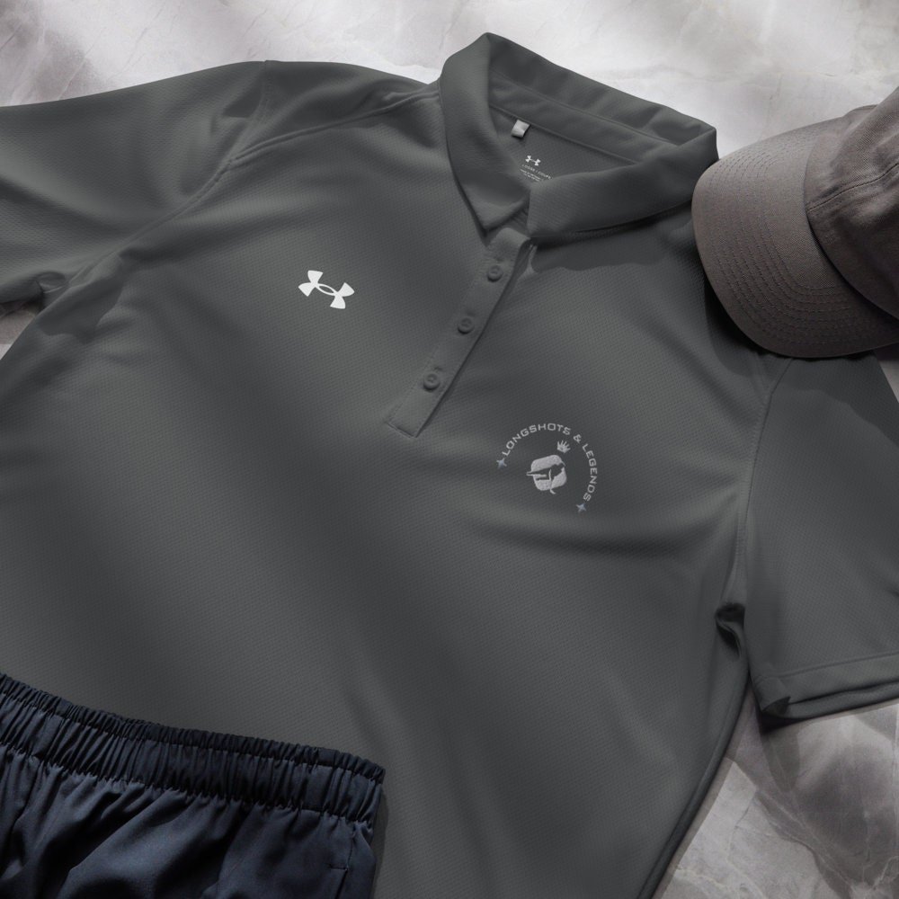Custom embroidered women’s Under Armour® collared polo shirt with hockey logo in dark gray. Celebrate with the Longshots and Legends collection of athletic wear.