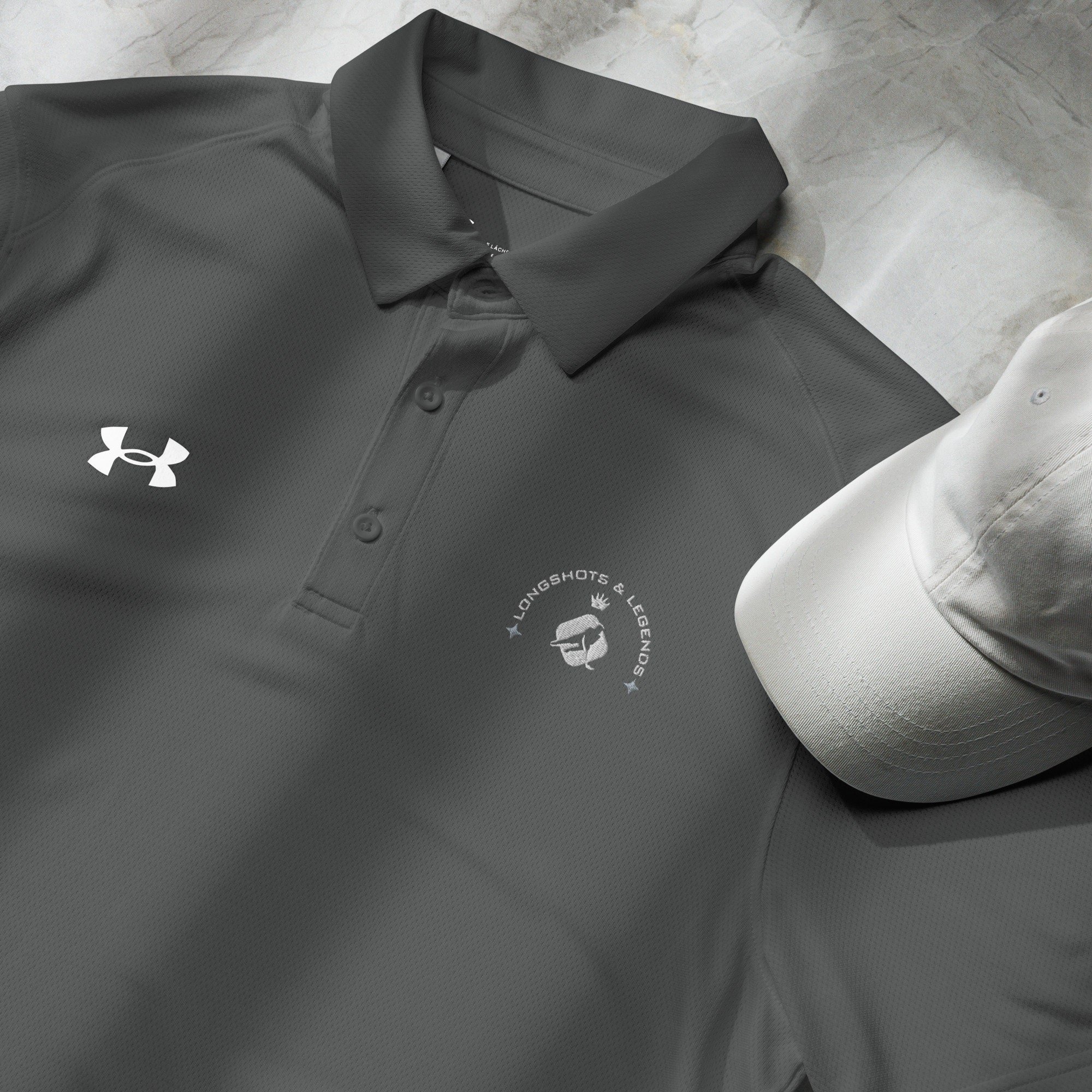 Custom embroidered men’s Under Armour® collared polo shirt with hockey logo in dark gray. Celebrate with the Longshots and Legends collection of athletic wear.