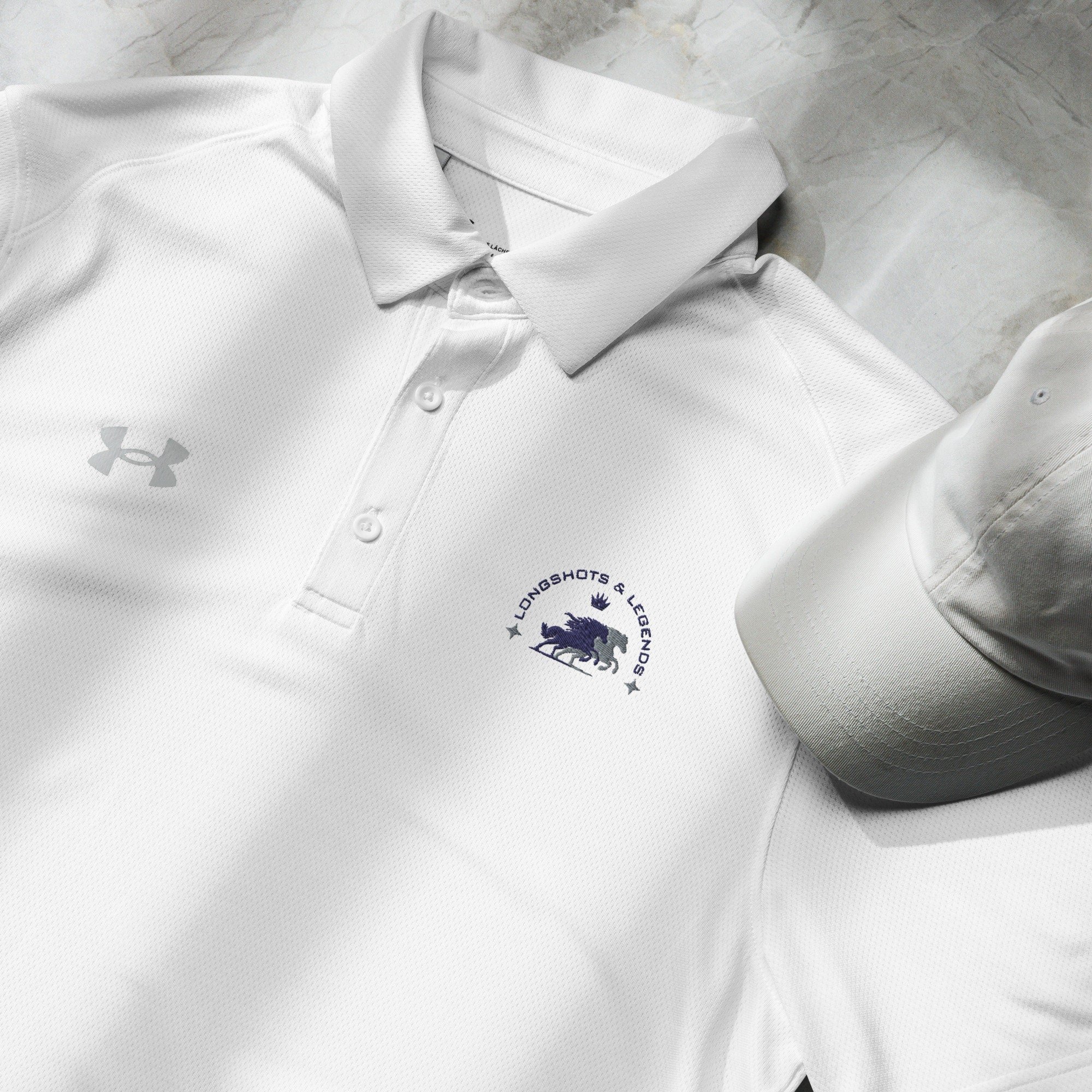 Custom embroidered men’s Under Armour® collared polo shirt with equestrian logo in white. Celebrate with the Longshots and Legends collection of athletic wear.