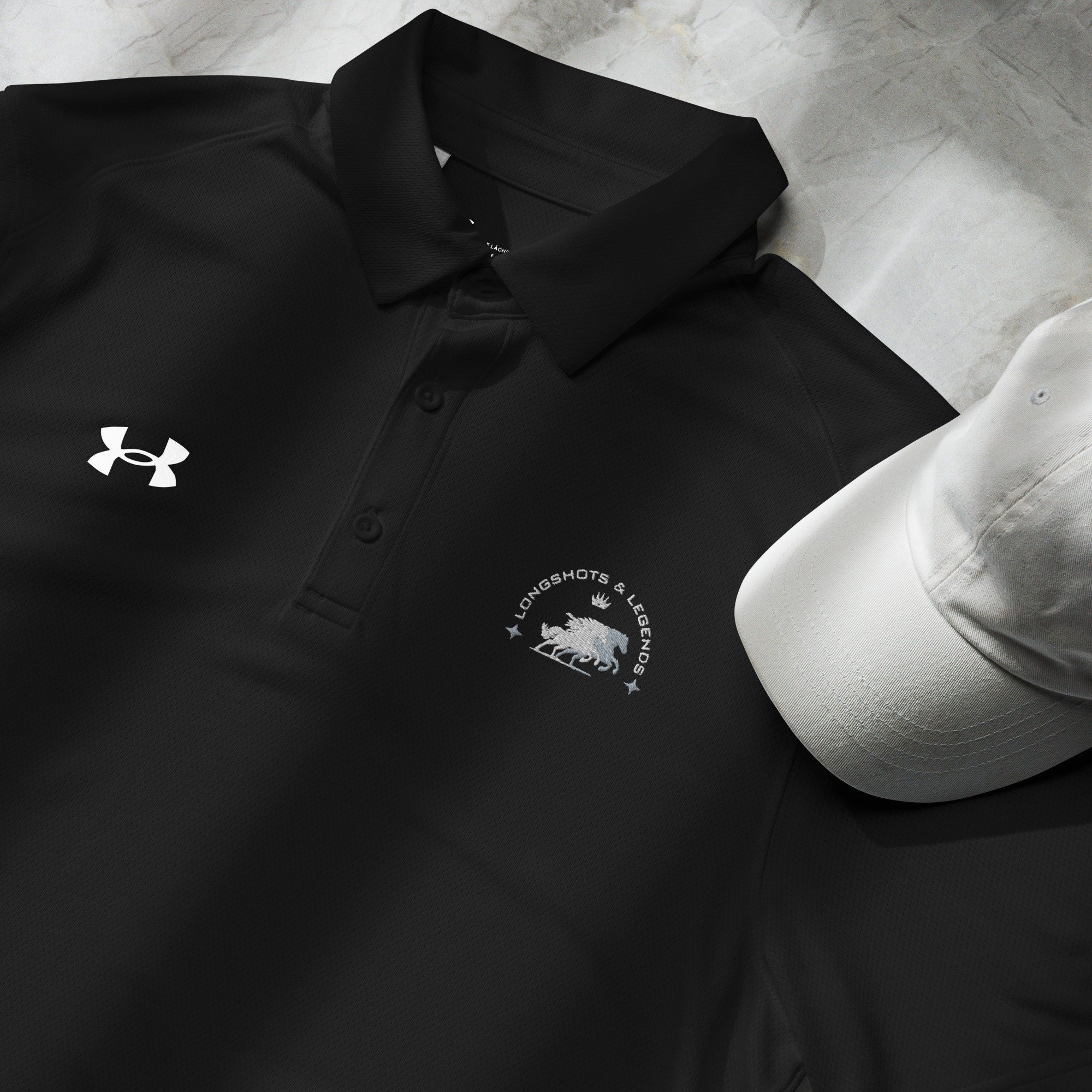 Custom embroidered men’s Under Armour® collared polo shirt with equestrian logo in black. Celebrate with the Longshots and Legends collection of athletic wear.