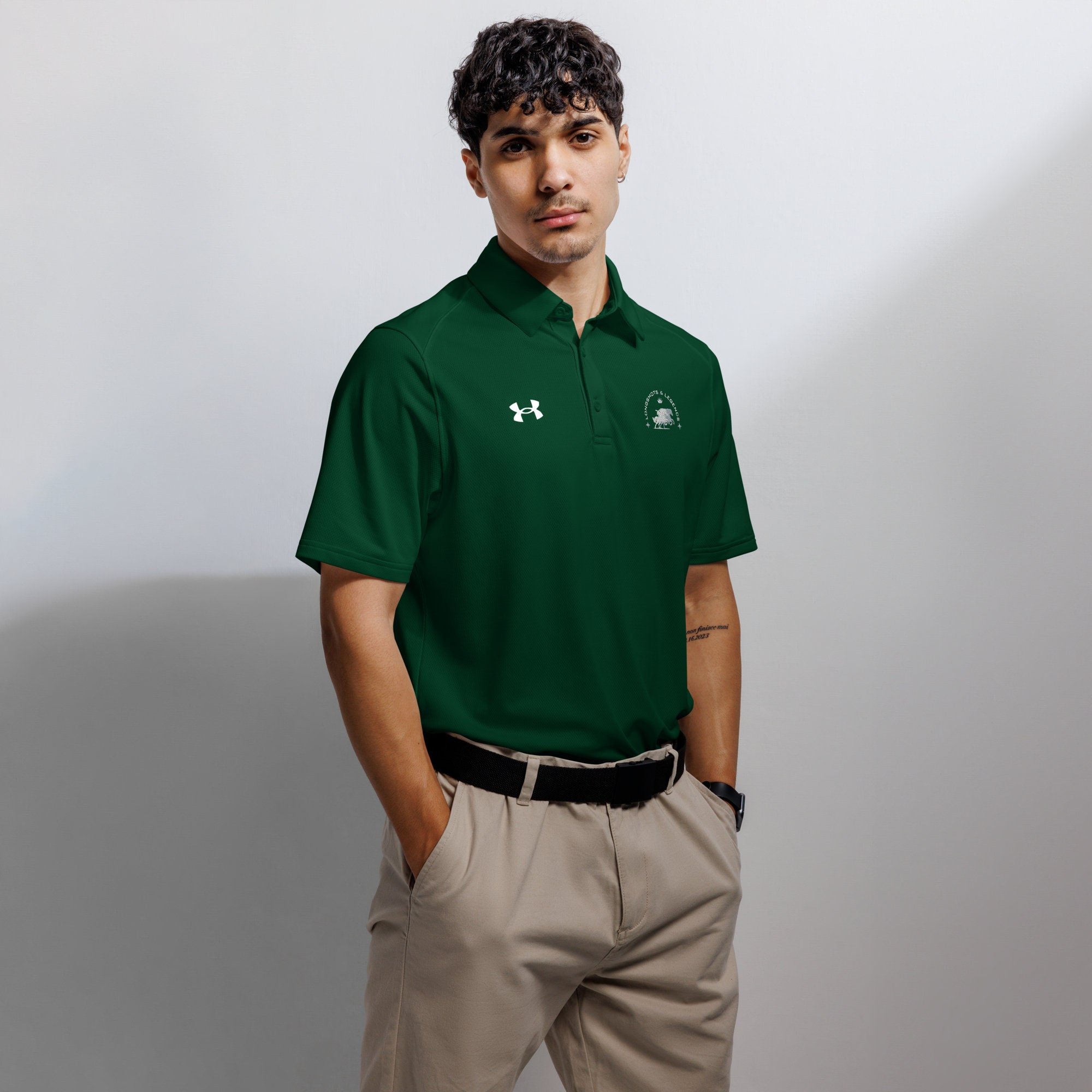 Custom embroidered men’s Under Armour® collared polo shirt with equestrian logo in spruce green. Celebrate with the Longshots and Legends collection of athletic wear.