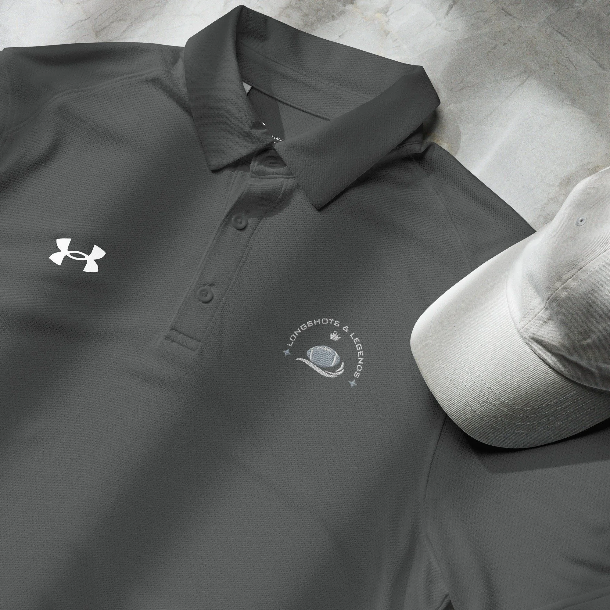 Custom embroidered men’s Under Armour® collared polo shirt with football logo in dark gray. Celebrate with the Longshots and Legends collection of athletic wear.