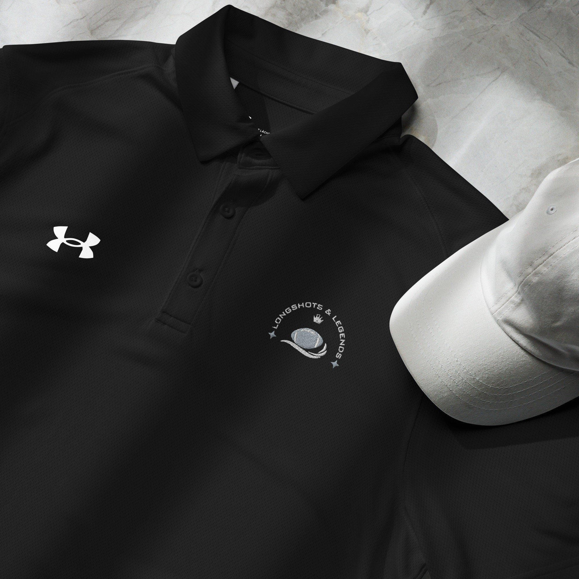 Custom embroidered men’s Under Armour® collared polo shirt with football logo in black. Celebrate with the Longshots and Legends collection of athletic wear.