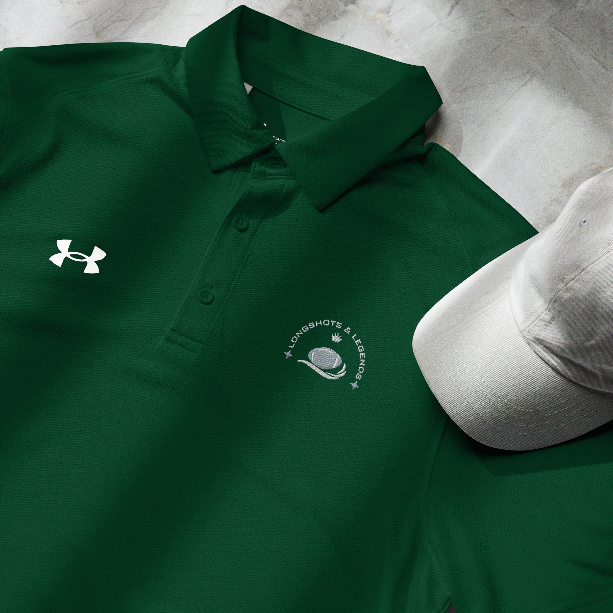 Custom embroidered men’s Under Armour® collared polo shirt with football logo in spruce green. Celebrate with the Longshots and Legends collection of athletic wear.