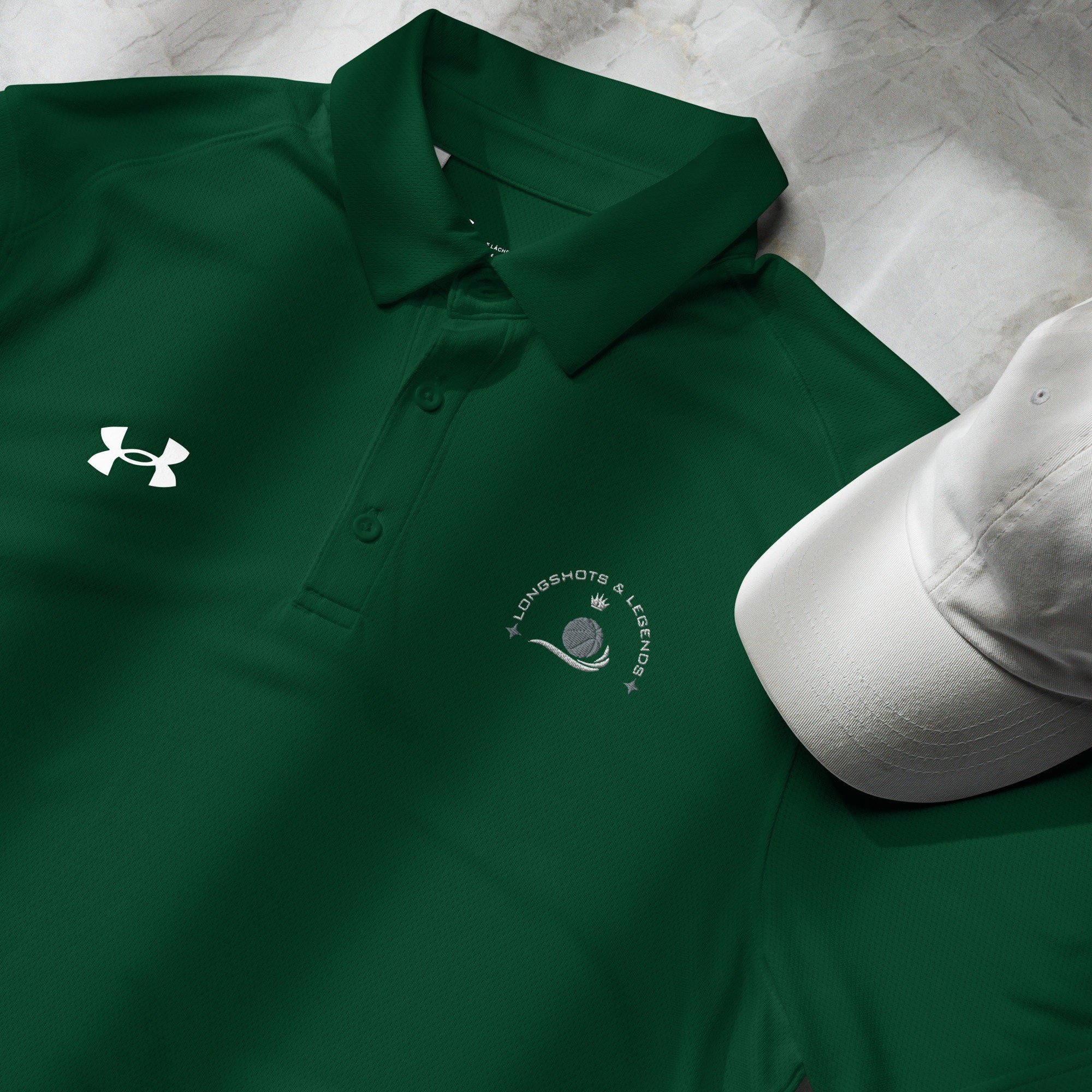 Custom embroidered men’s Under Armour® collared polo shirt with basketball logo in spruce green. Celebrate with the Longshots and Legends collection of athletic wear.
