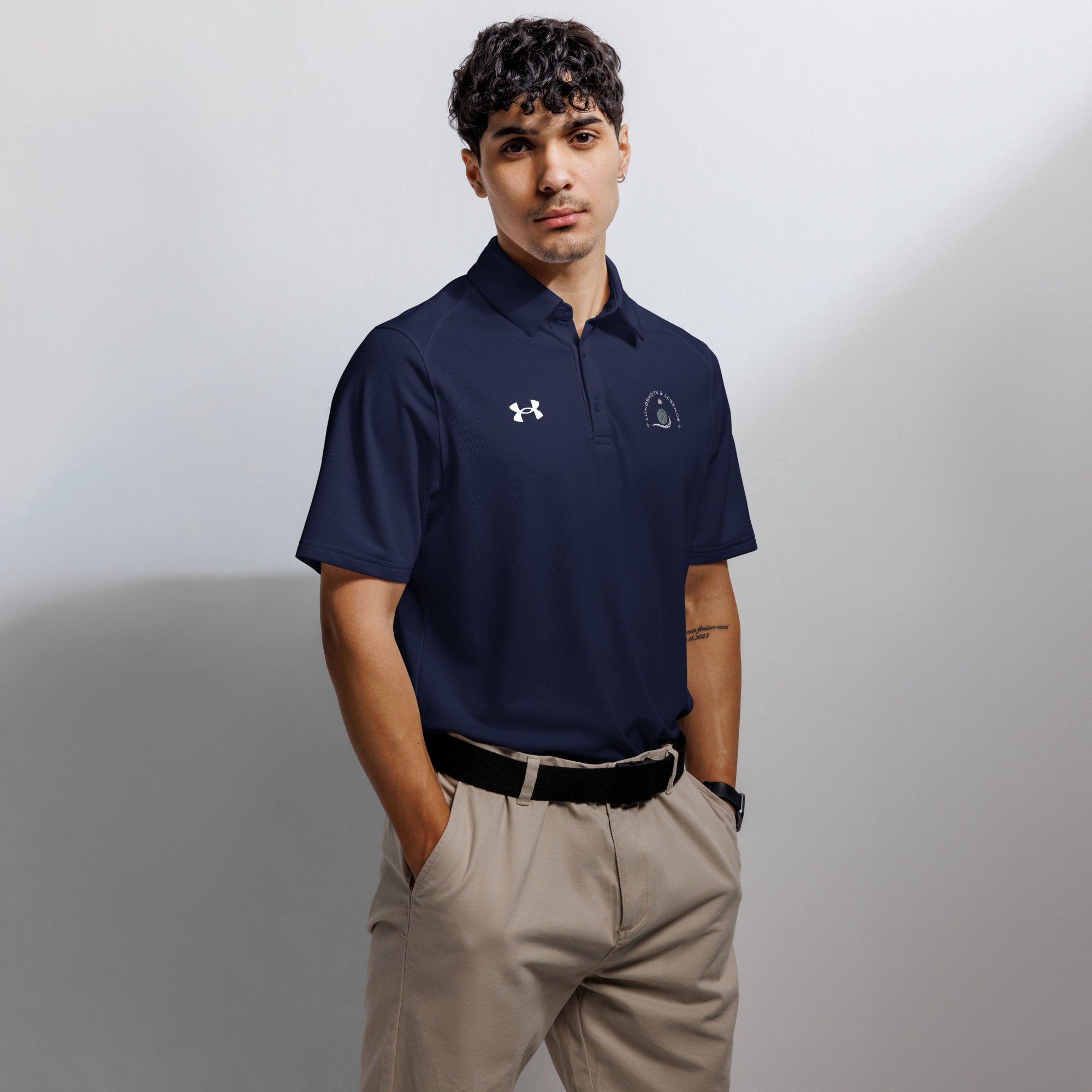 Custom embroidered men’s Under Armour® collared polo shirt with basketball logo in navy blue. Celebrate with the Longshots and Legends collection of athletic wear.