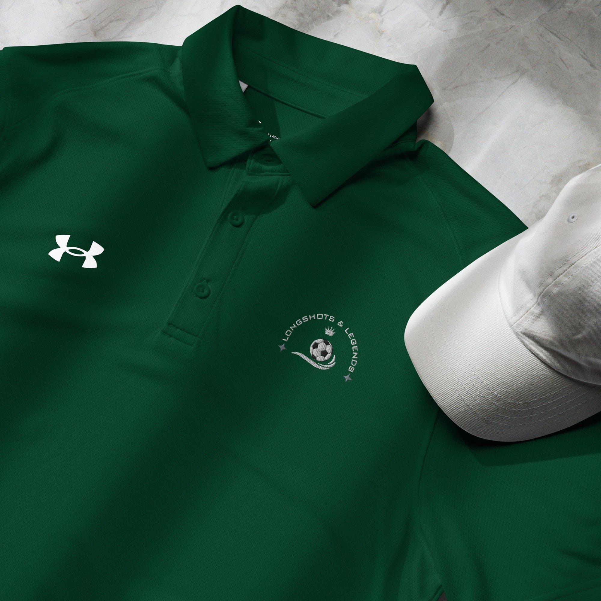 Custom embroidered men’s Under Armour® collared polo shirt with soccer logo in spruce green. Celebrate with the Longshots and Legends collection of athletic wear.