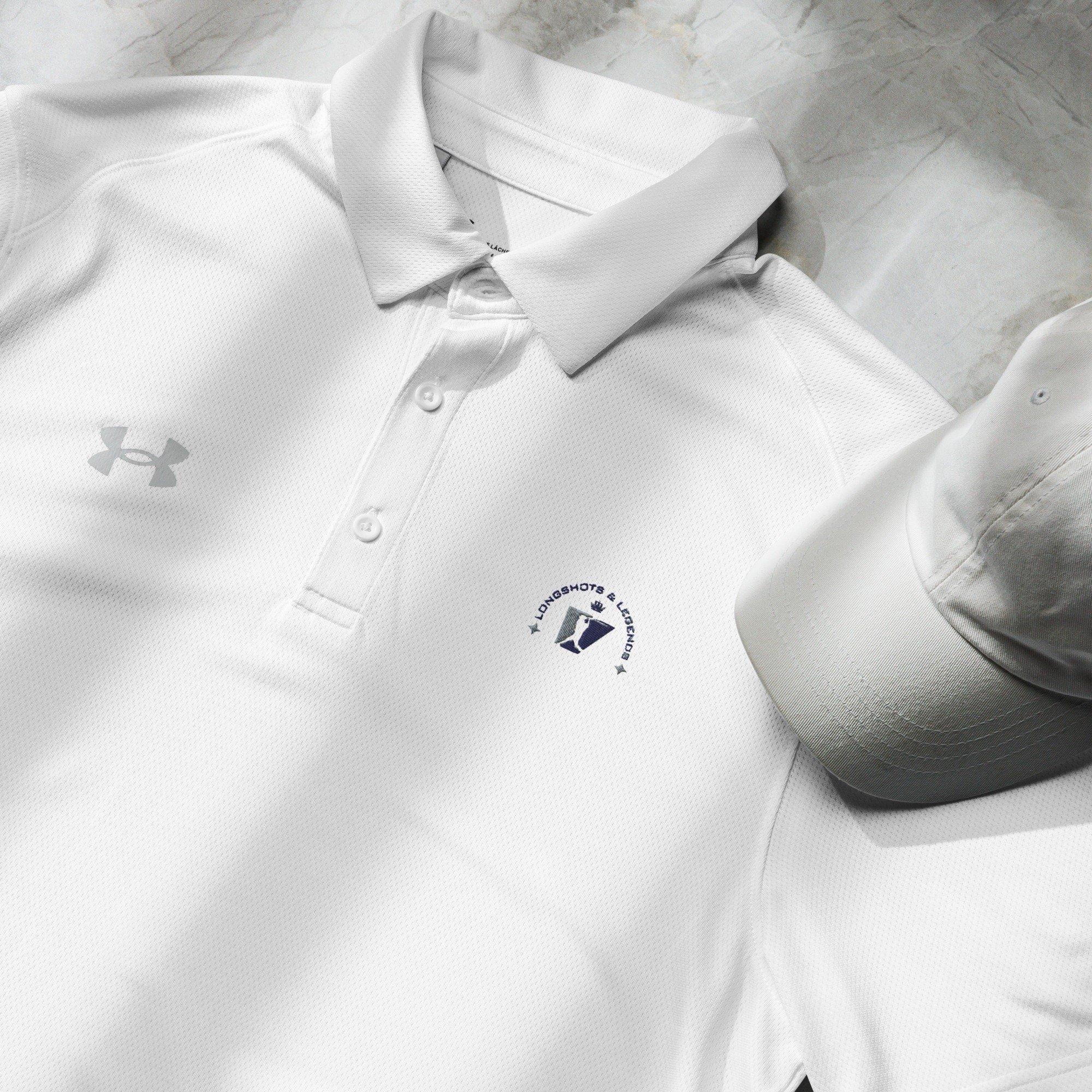 Custom embroidered men’s Under Armour® collared polo shirt with baseball logo in white. Celebrate with the Longshots and Legends collection of athletic wear.