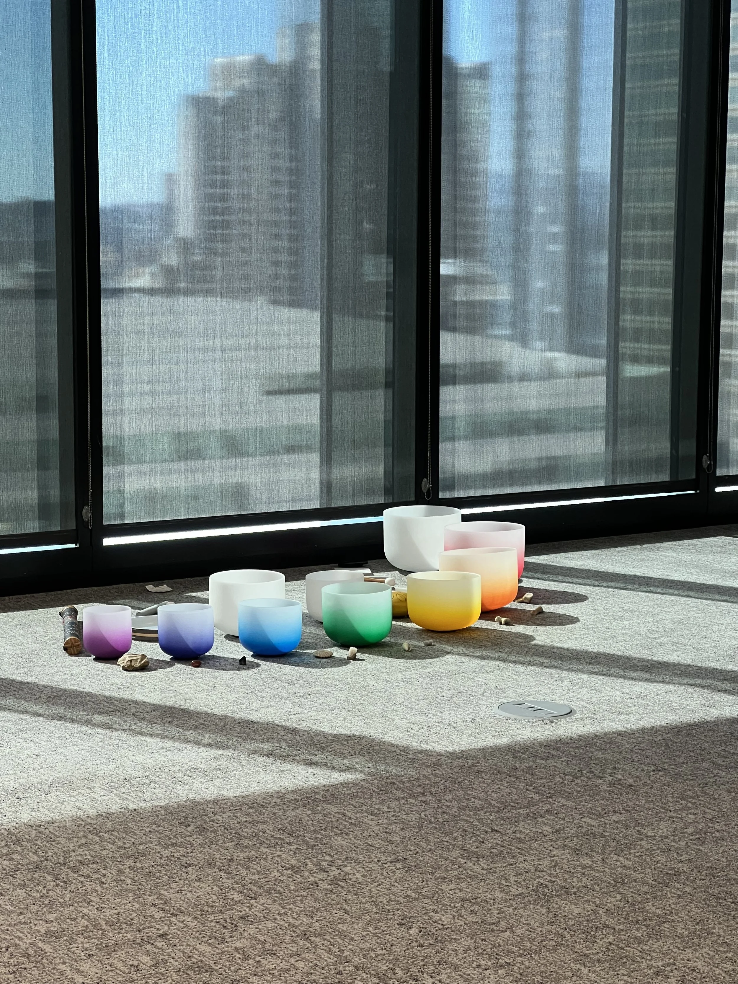 Colorful crystal singing bowls and chimes for a private soundbath session by Well With Avril for a corporate team in San Francisco
