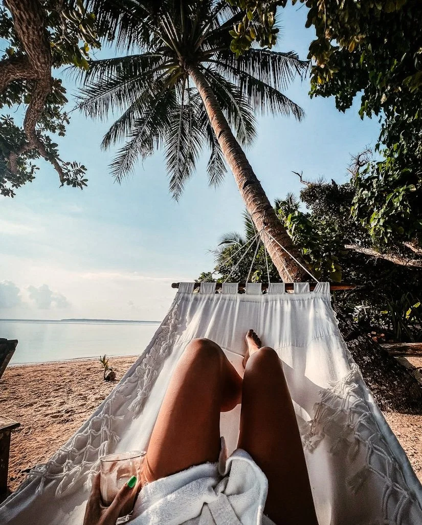Well With Avril guest hammock chilling on the white sand beach during Siargao, Philippines yoga retreat