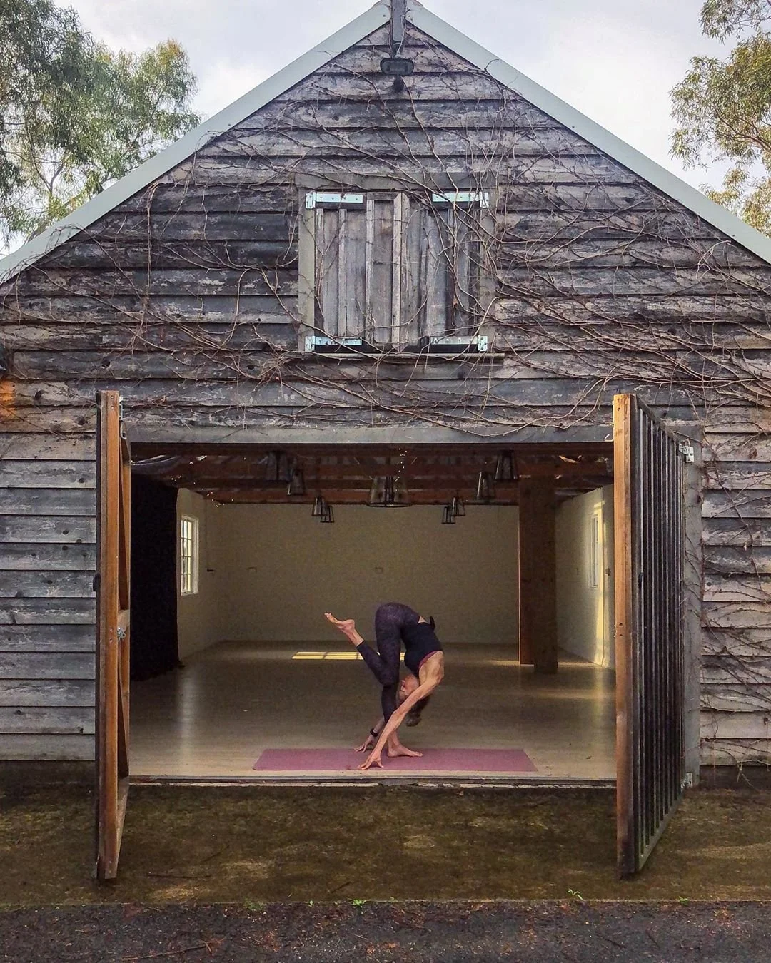 Kirsten in barn doing yoga view from garden.jpg