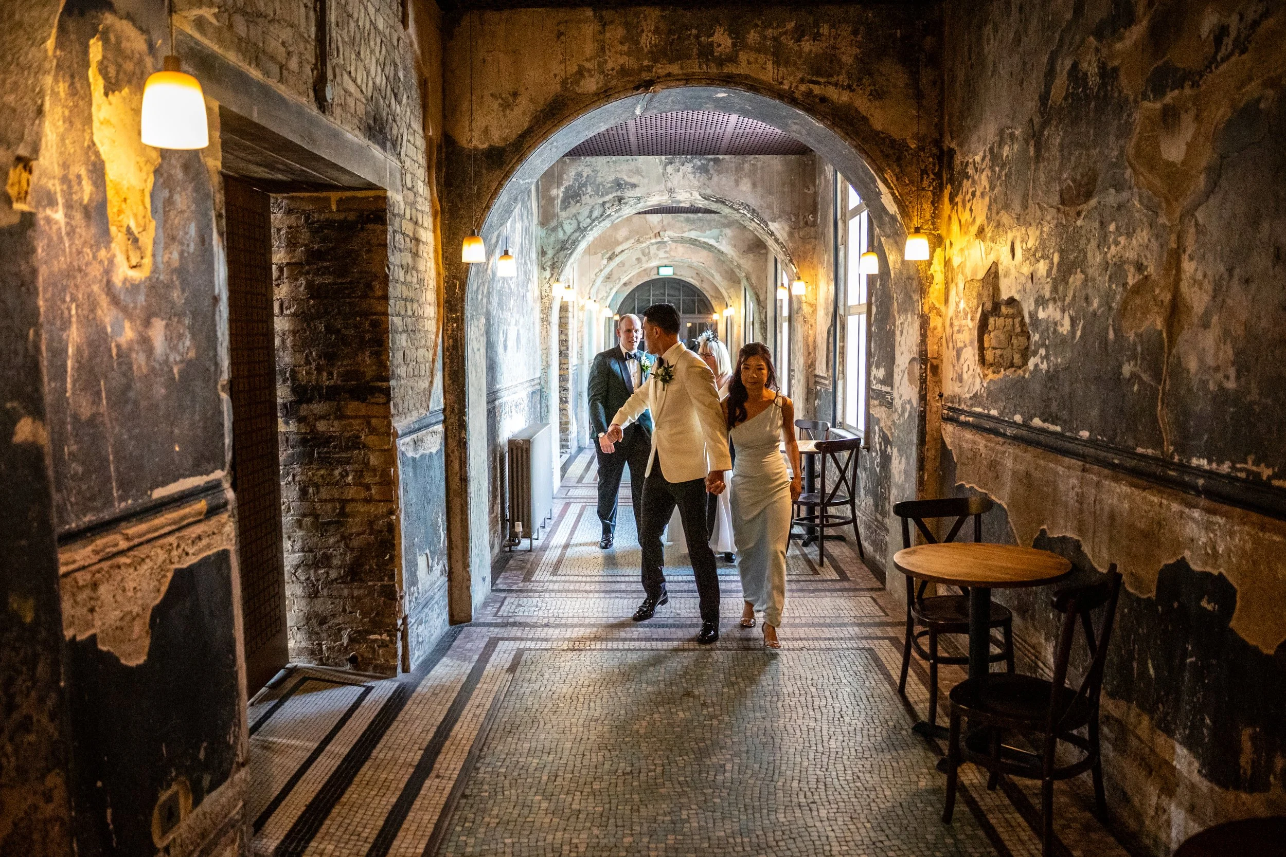 Kevin and James and a loved one walking down a corridor where the walls have clearly been damaged by fire.