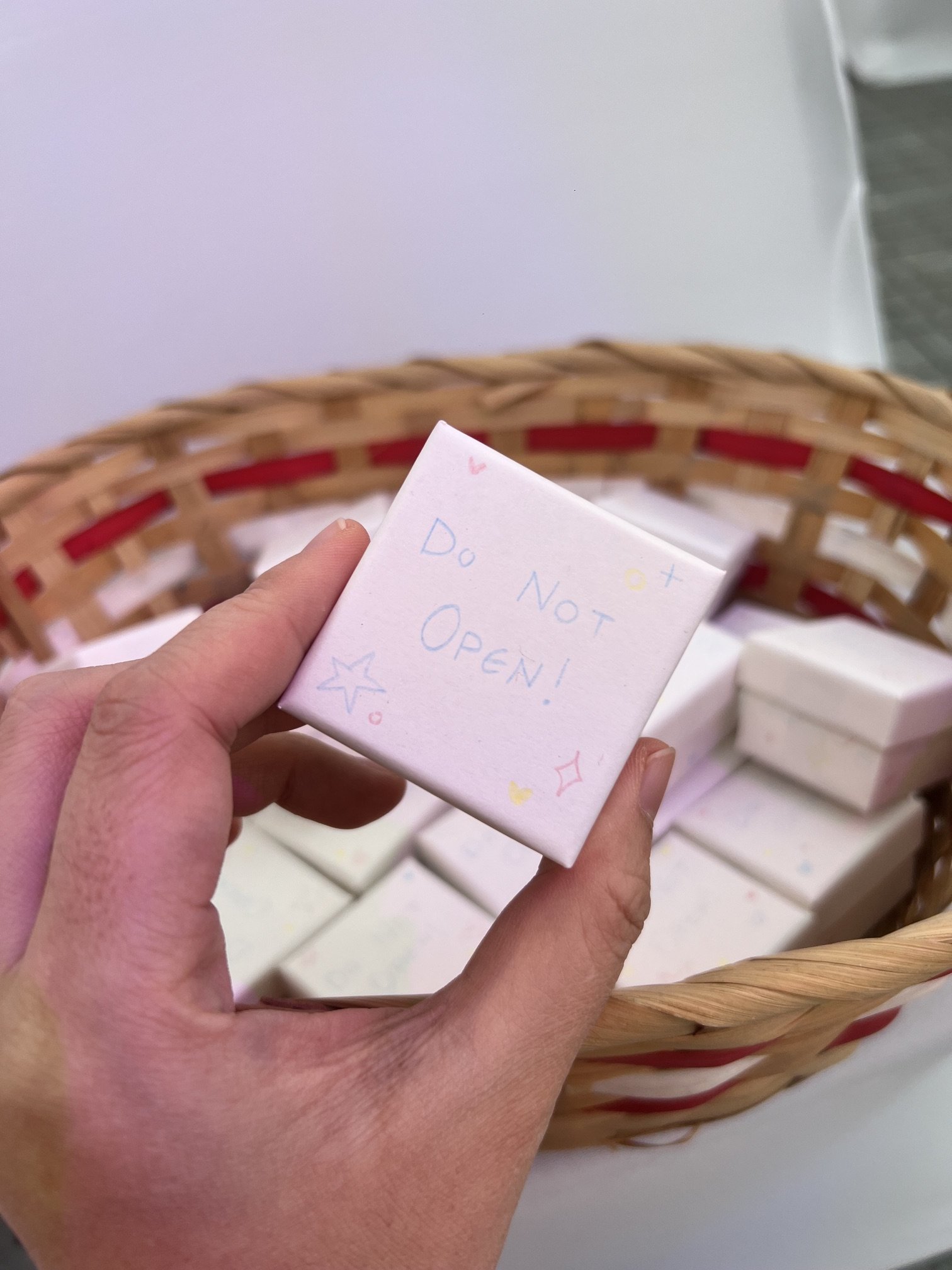 A small white paper box with "DO NOT OPEN!" written on it and little stars drawn around the writing.