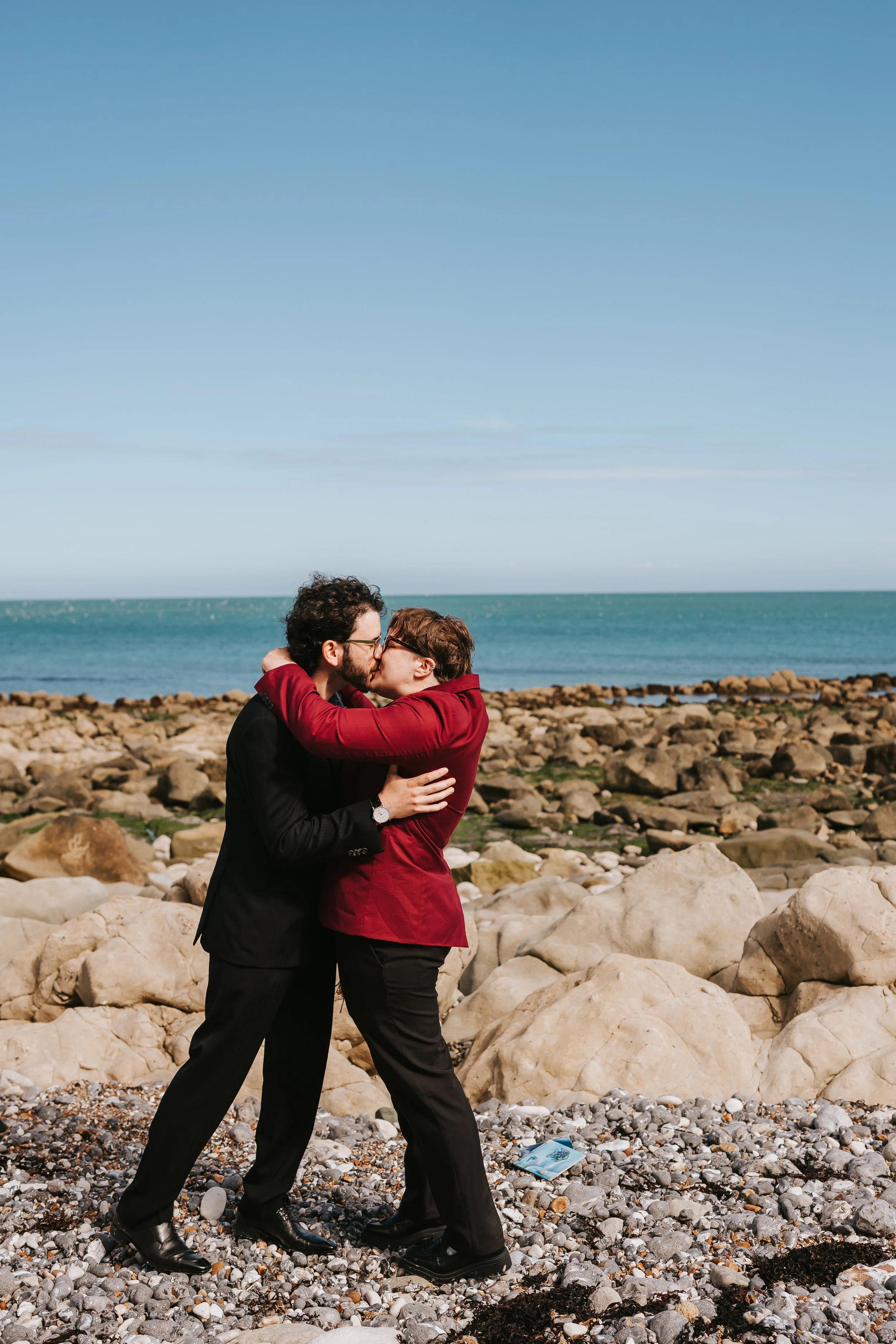 Brigid and Issac kiss to conclude their beach elopement ceremony with the sea in the background.