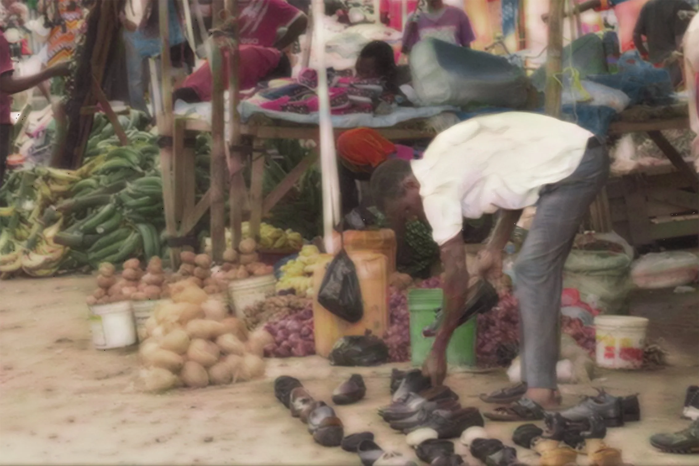Laying Out Shoes: Arranging shoes is a single, repeated act; the market may be crowded, and customers may or may not appear. Yet the dedication to one task that secures food for his table that day makes it powerful.