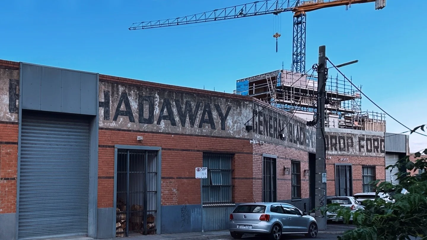 Forged in Richmond:
EJ HADAWAY
GENERAL BLACKSMITH &amp; DROP FORGE

The ghost sign looms in 5,669 pt font, running almost a full block in letters that would overshadow even a Dodge Ram 1500, and staring down the blue-and-yellow pop-art signage of IKE