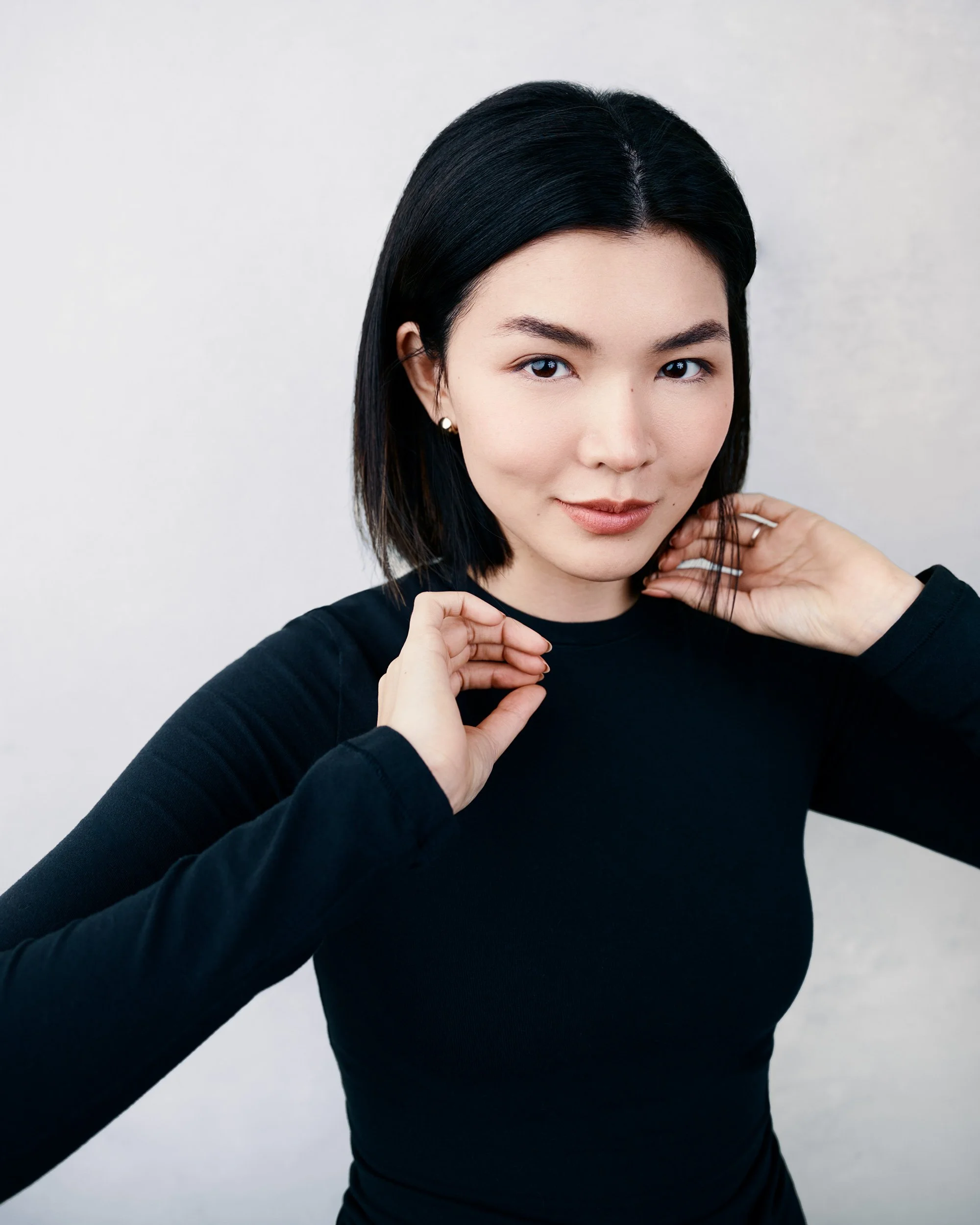 Professional company headshot close-up of woman in black top with clean white background