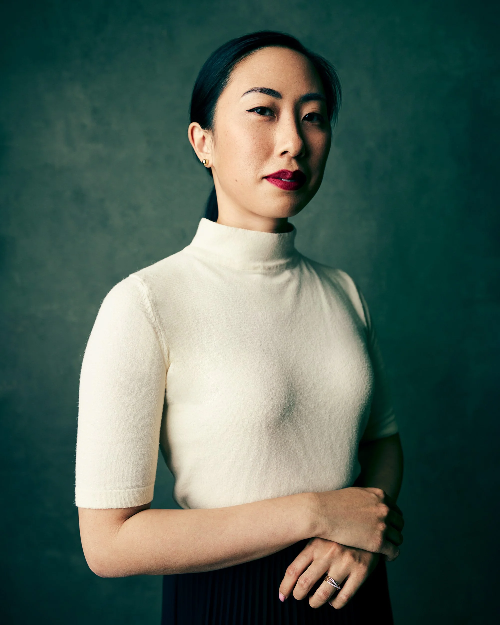 CEO headshots studio portrait, female executive; dramatic light, soft gradient textured backdrop; calm waist-up composition.