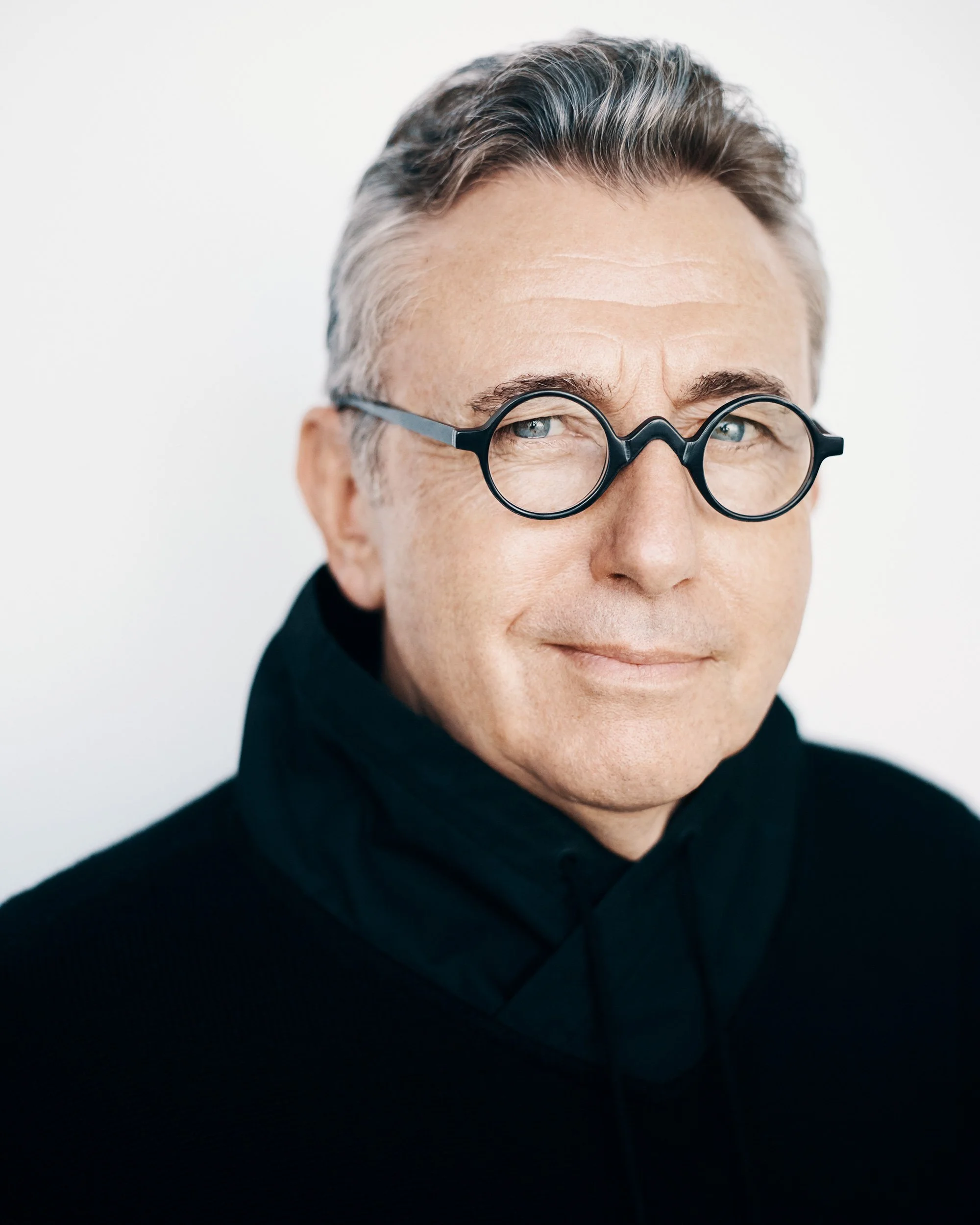 CEO headshots studio portrait, male executive, natural even lighting, white backdrop, head-and-shoulders framing.