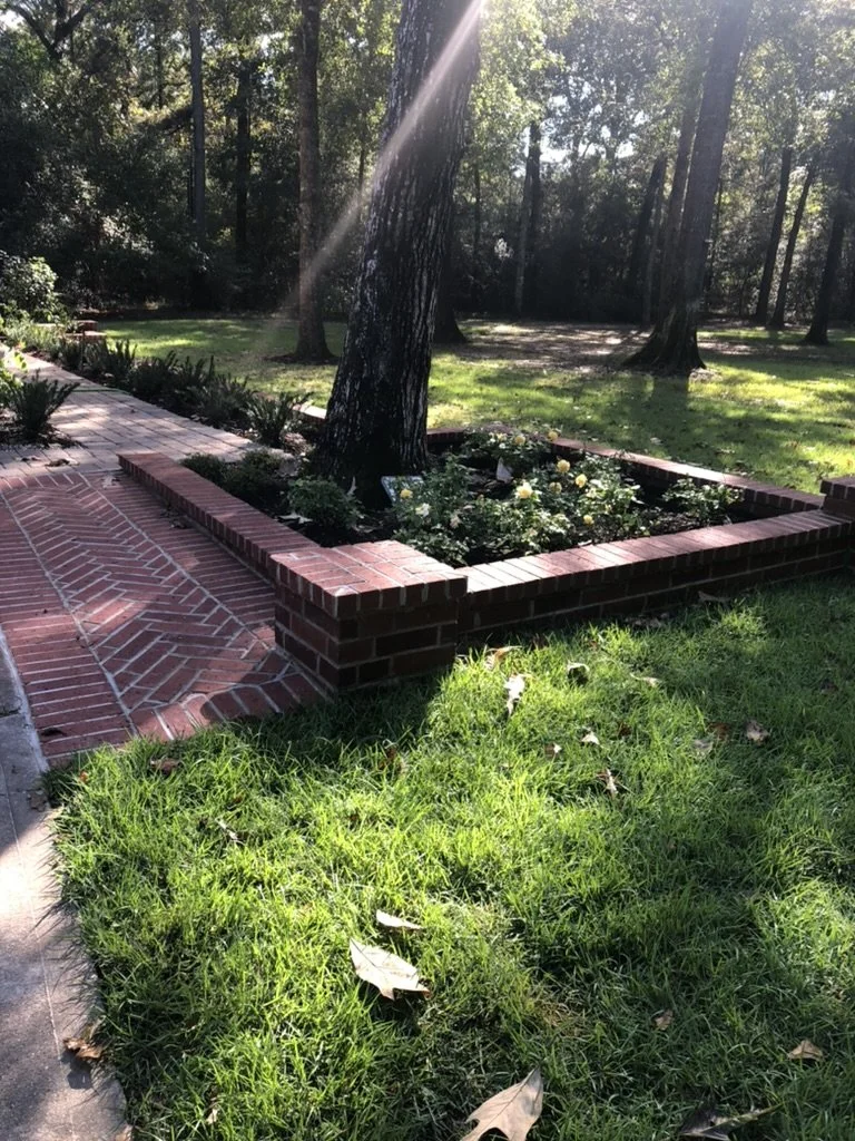 Red brick planter beds with podiums.