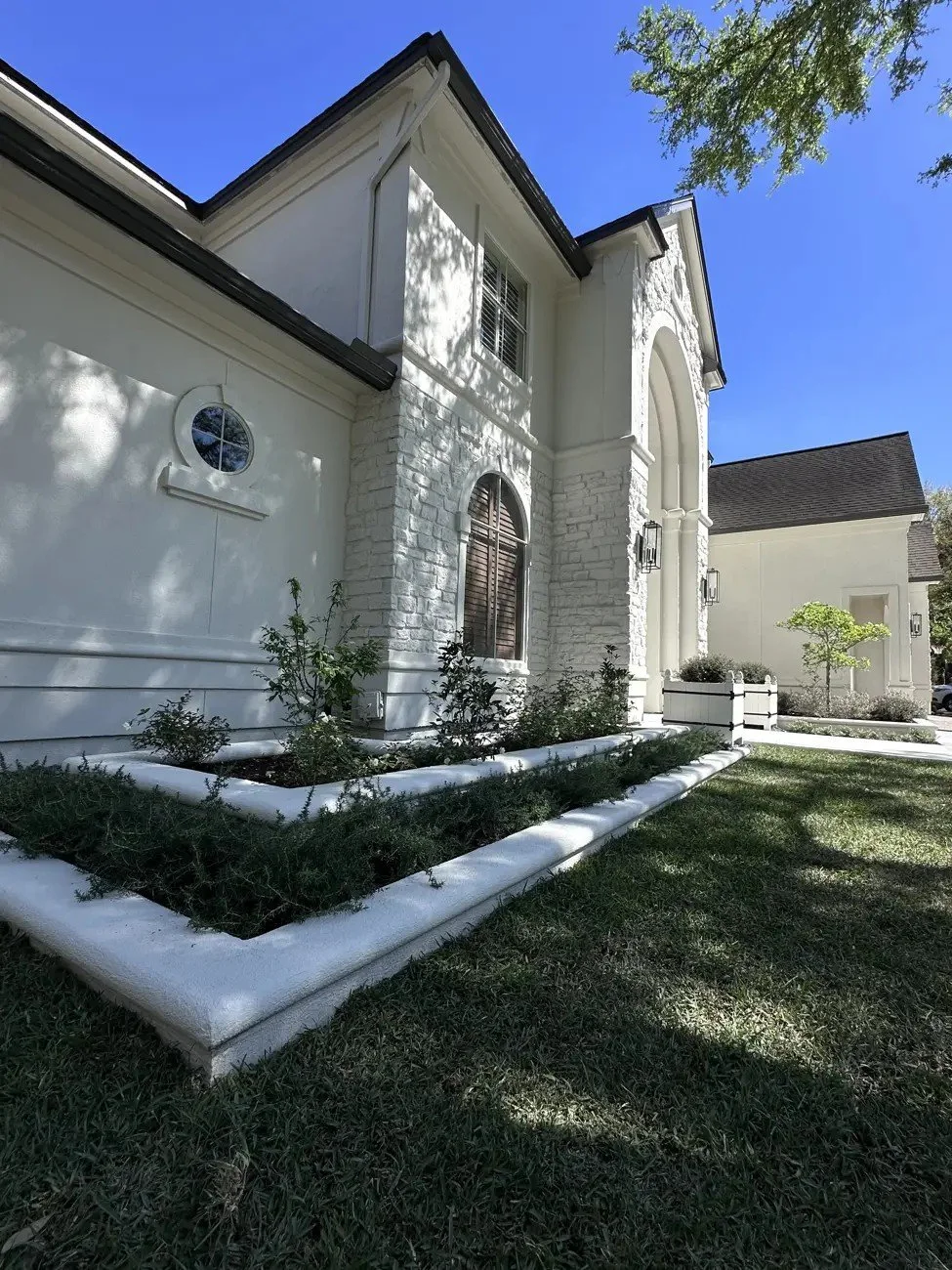 After: white stucco raised beds and a prostrate rosemary trough at the front corner of the house, Cochran's Crossing, The Woodlands TX