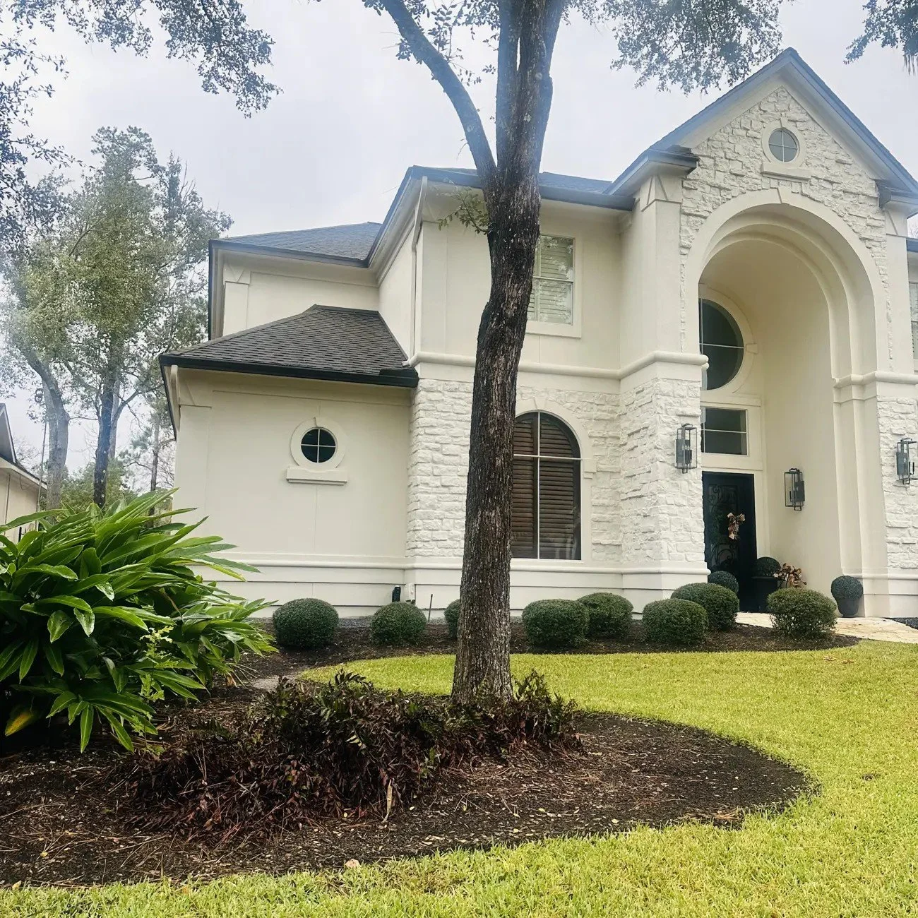 Before: front corner of the house with low shrubs, an old clump of variegated alpinia ginger and an open mulch bed, Willowcrest Place, Cochran's Crossing, The Woodlands TX