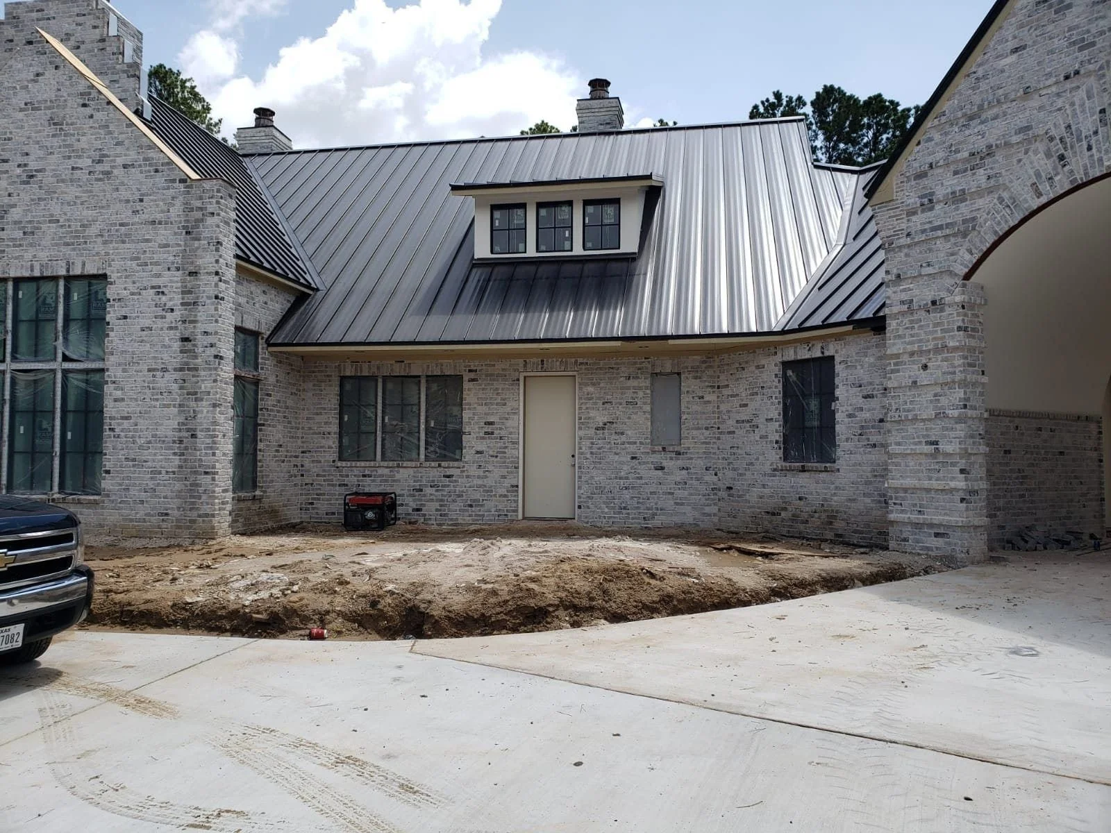 Before: the bare front courtyard of the white-brick home
