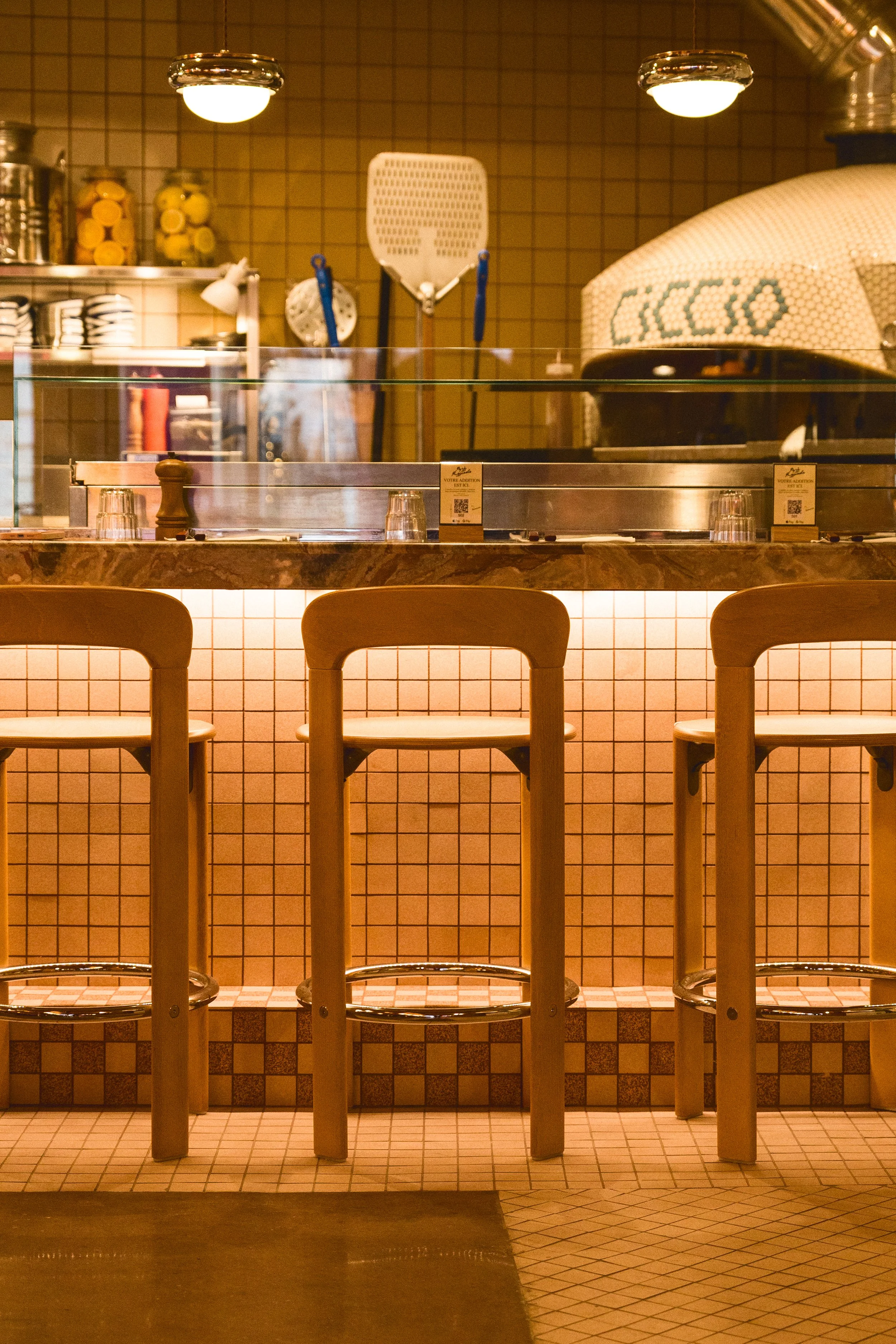 Tabourets de bar devant four artisanal à pizza