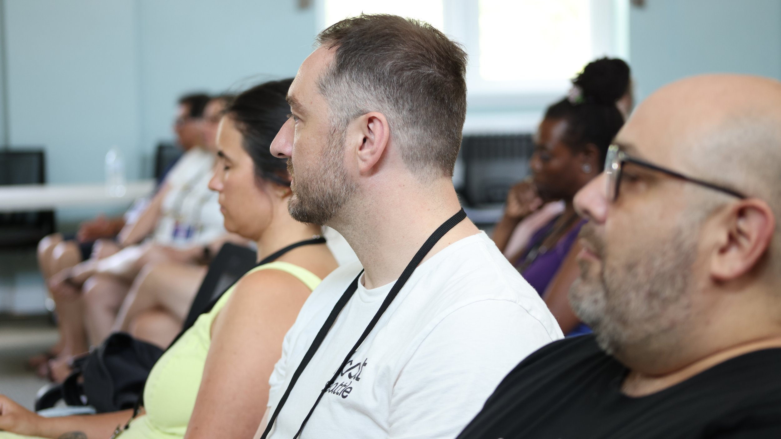 Side view of diverse people sitting in a conference or seminar, attentively listening.