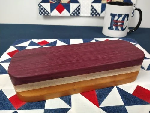 Purple Heart Quilters Clapper by Keystone Carving llc displayed on a table