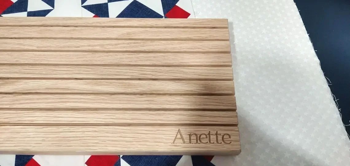 showing the top down view of a quilt ruler holder with the name Anette wood carved into the bottom right corner