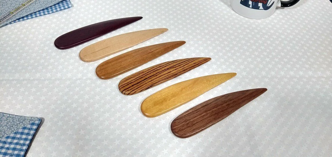 six different handmade point turners displayed on a patriotic white star cotton fabric