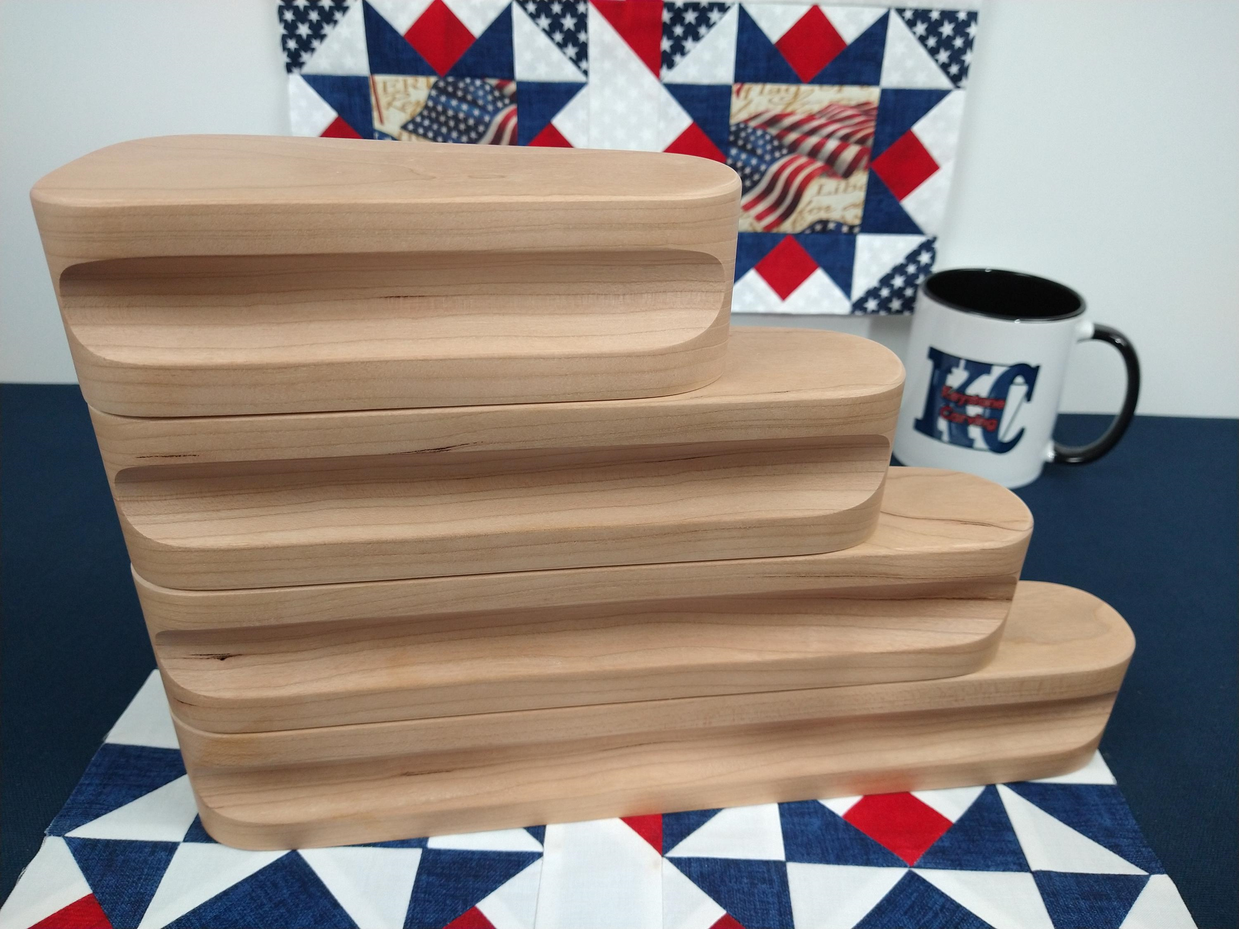 display of four different sized cherry tapered tailors clappers stacked together looking at the side edge on a patriotic quilt block