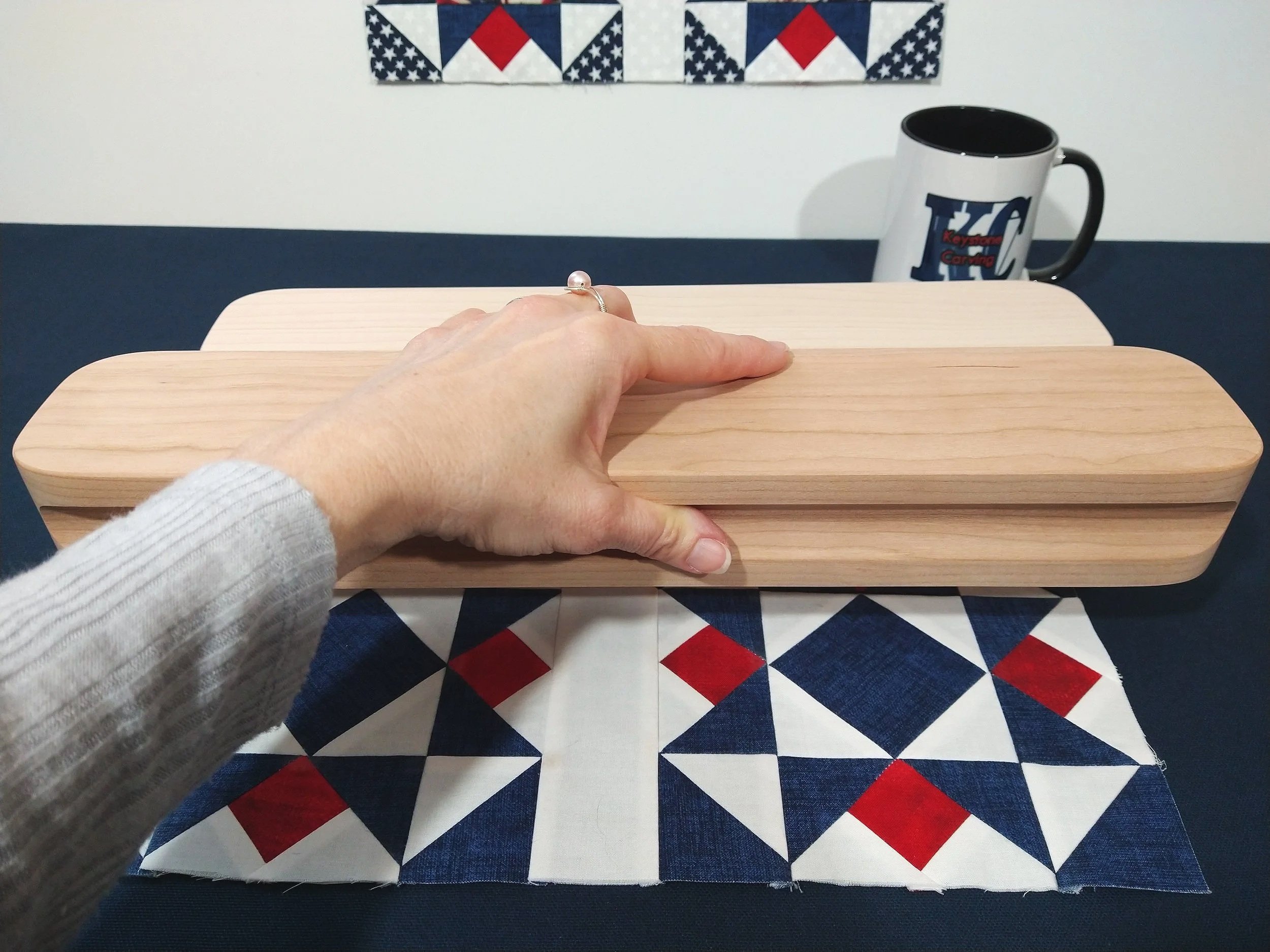 hand holding a larger cherry tailors clapper showing ease of use.