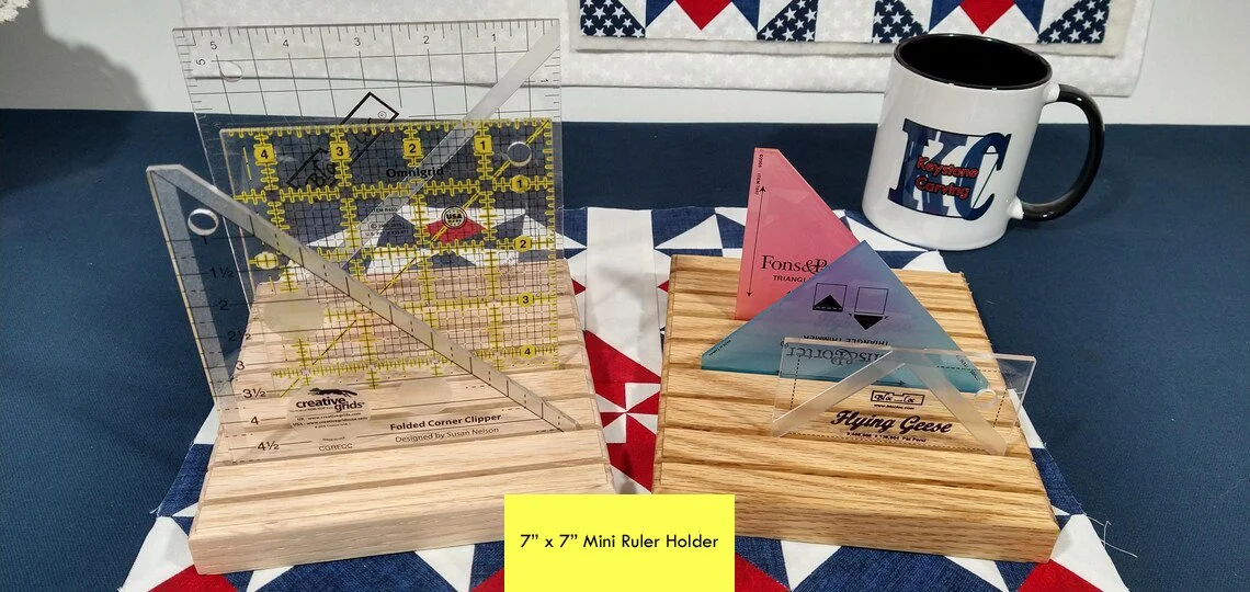 Image showing the mini quilt ruler holder displayed with quilt rulers in the grooves. They are setting on top of an Americana decor quilt block