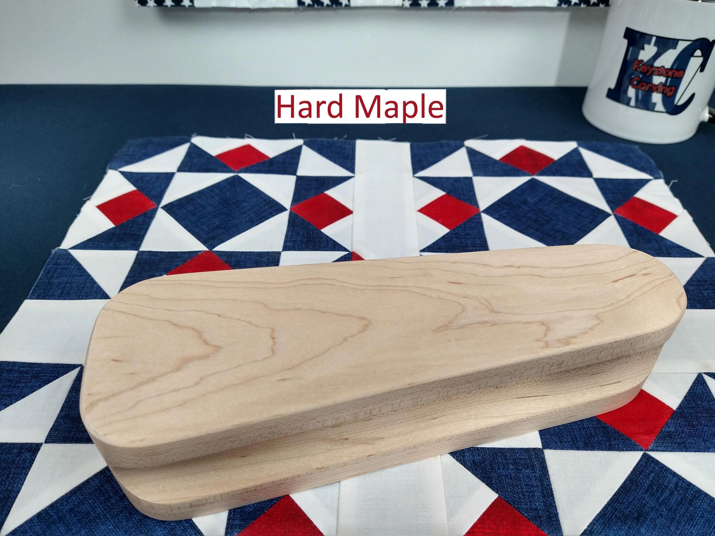 eight and one half inch tapered cherry hardwood tailors clapper setting on an Americana quilt block