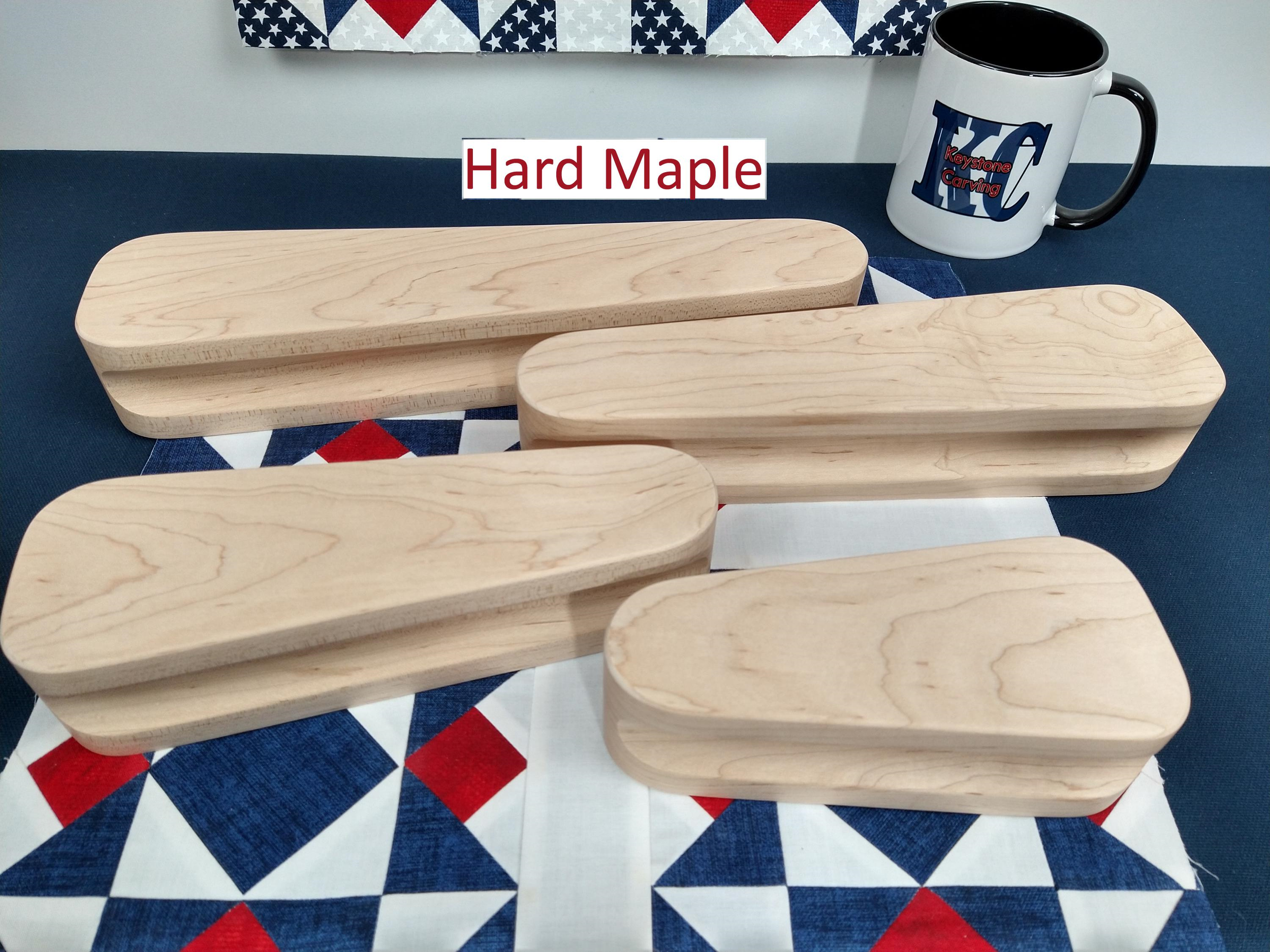 display of four different sized maple tapered tailors clappers arranged flat on a patriotic quilt block